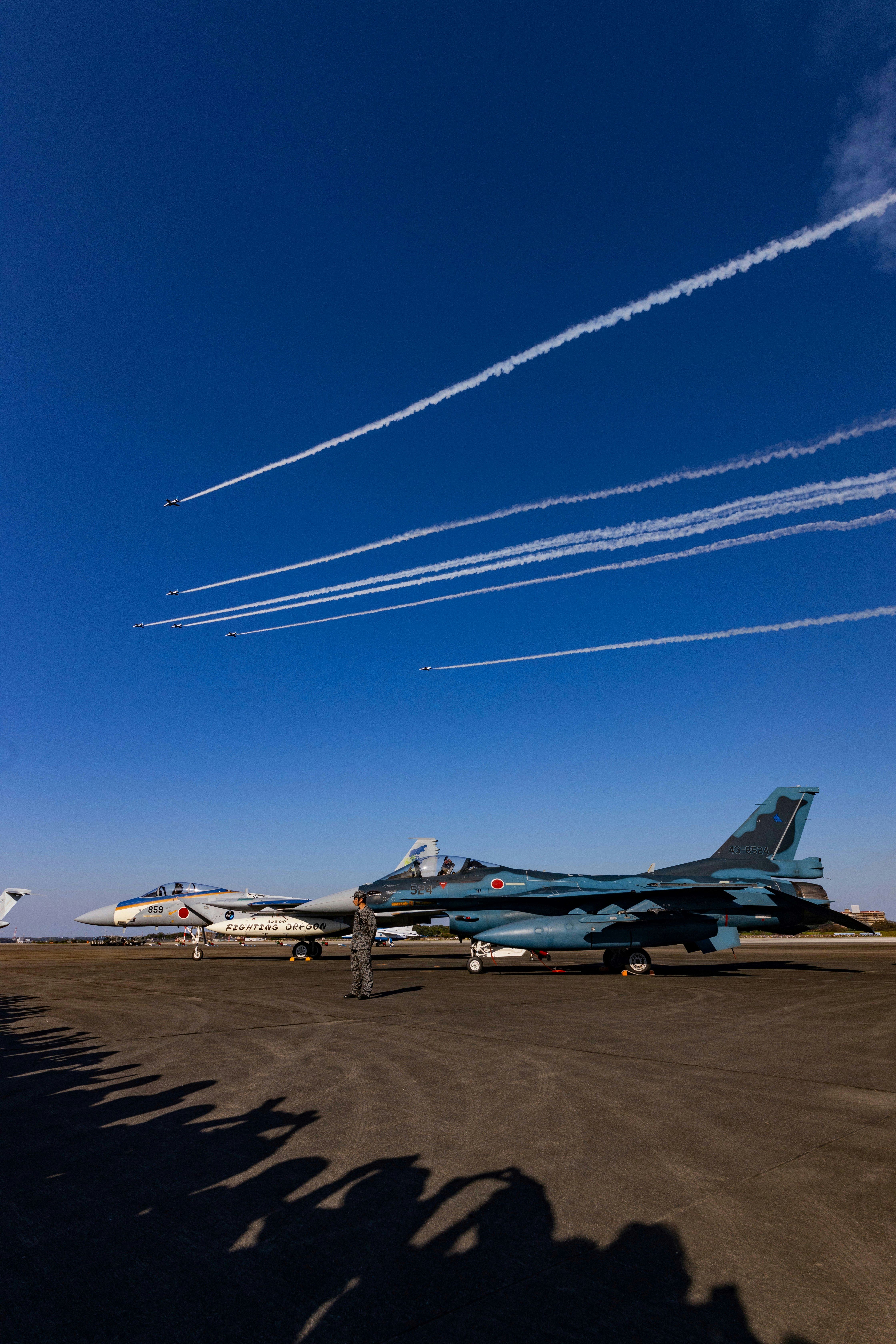 滑走路に並ぶ戦闘機と航空機のある基地の風景
