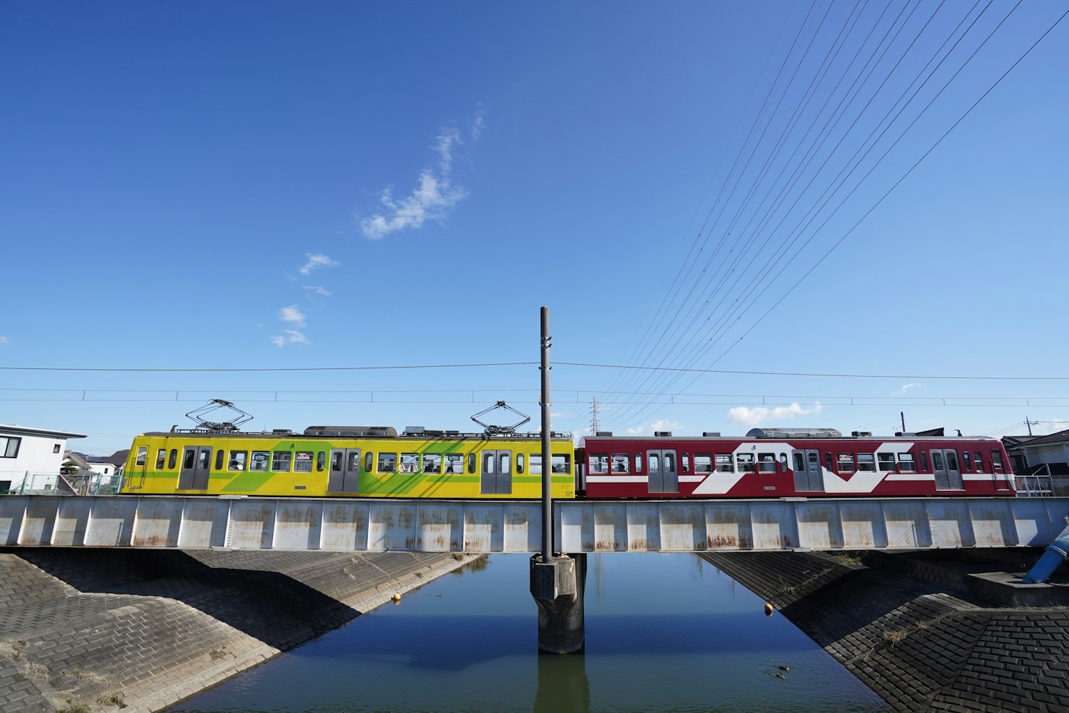 Lebendige gelbe und rote Züge, die über eine Brücke fahren