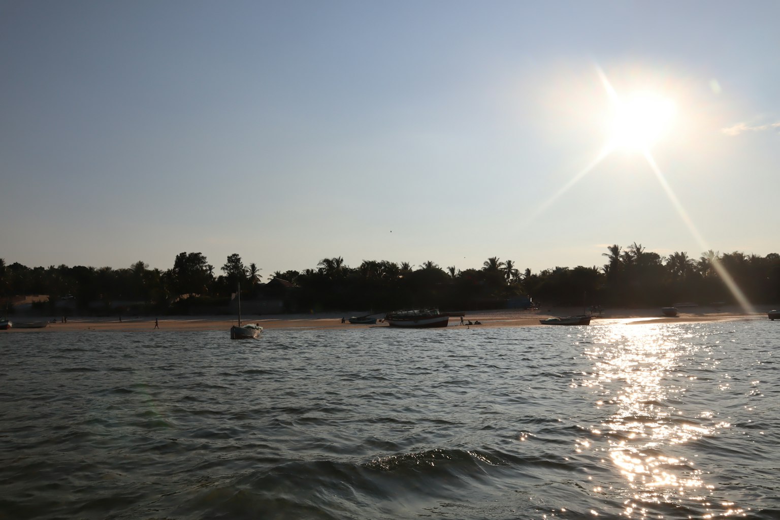 Pemandangan laut yang indah dengan perahu saat matahari terbenam sinar matahari bersinar