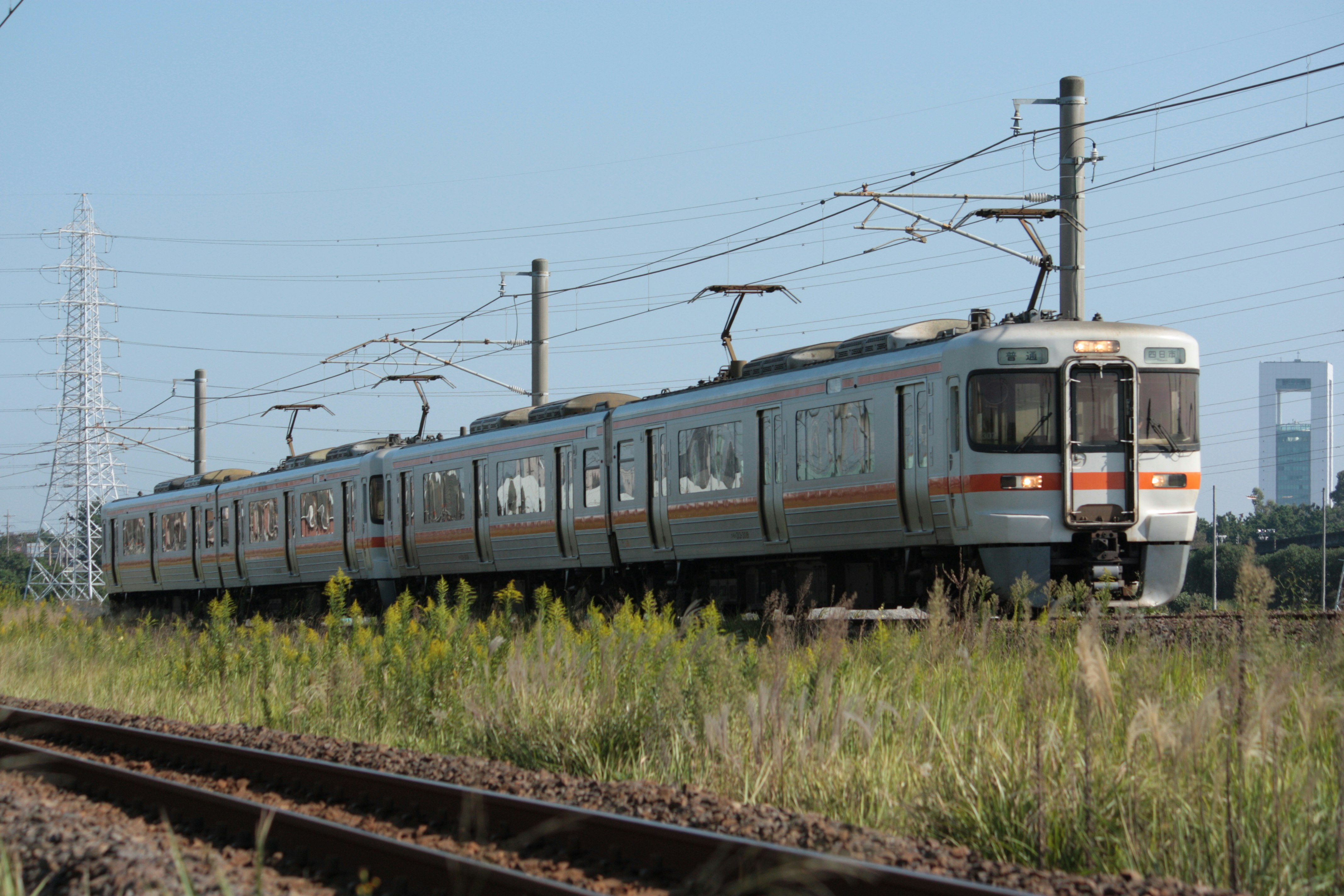 電車在郊外鐵軌上行駛的場景與架空接觸網