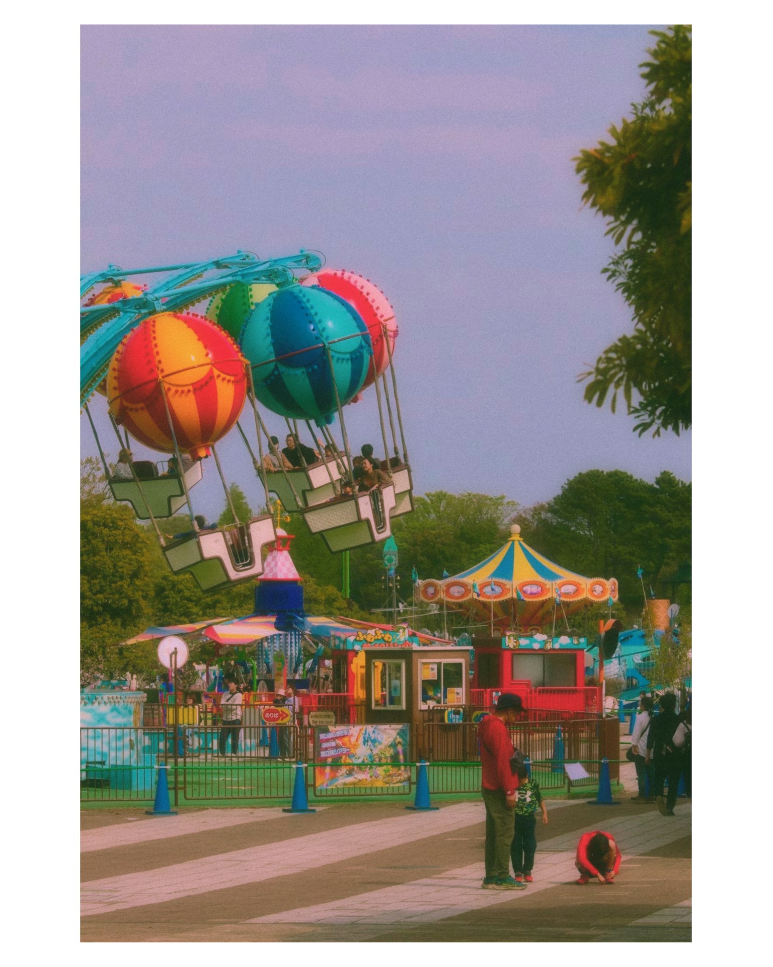 色とりどりの風船に乗った観覧車がある遊園地の風景