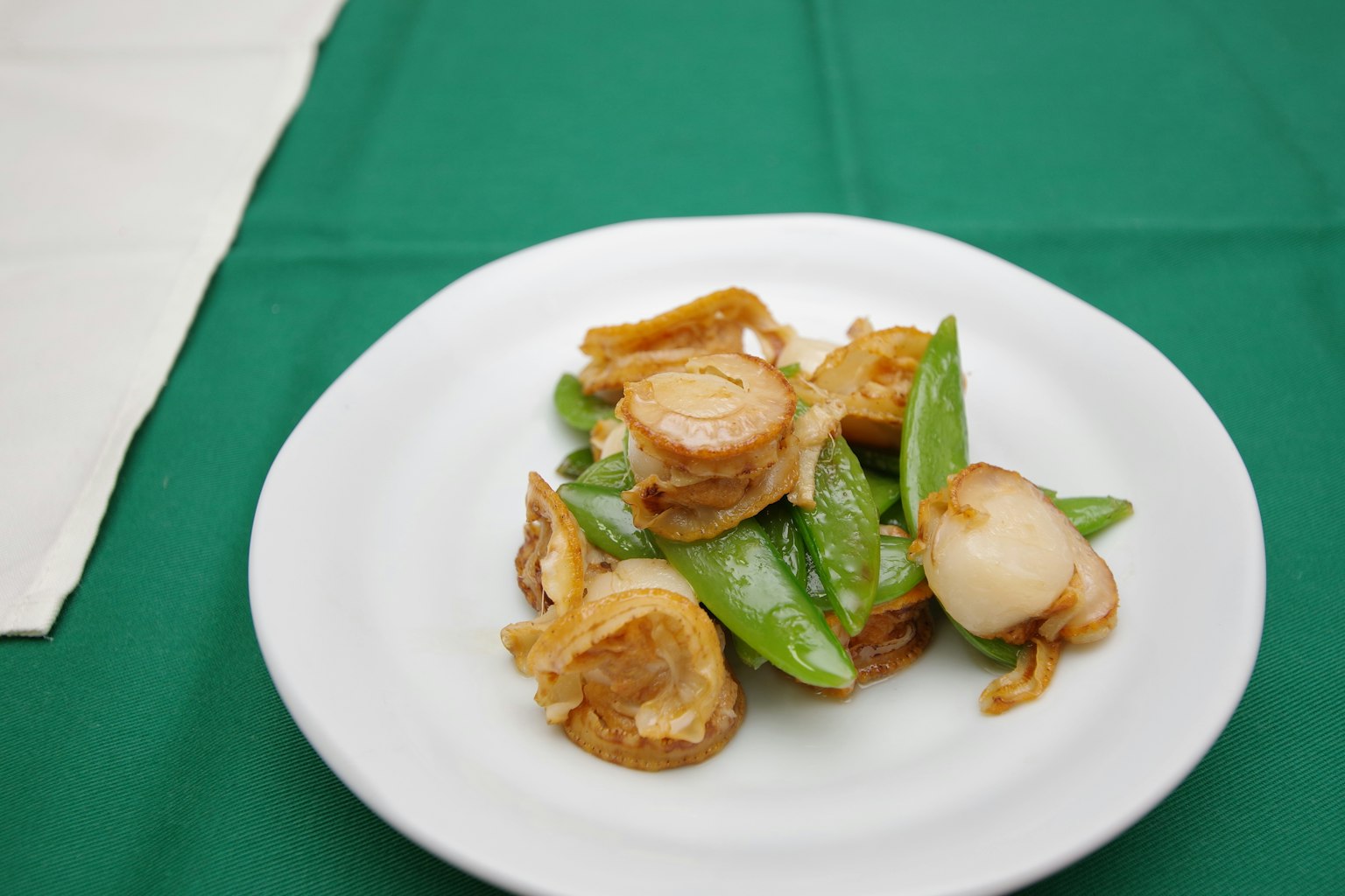 Hidangan kacang manis dan bawang goreng di piring putih