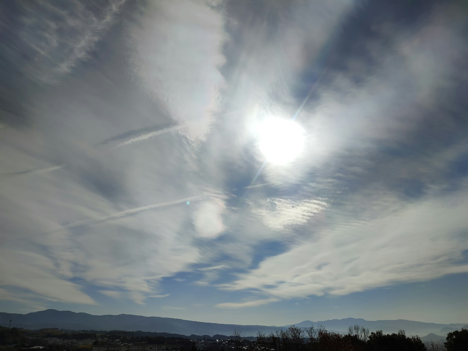 Paesaggio luminoso con nuvole e sole in un cielo blu