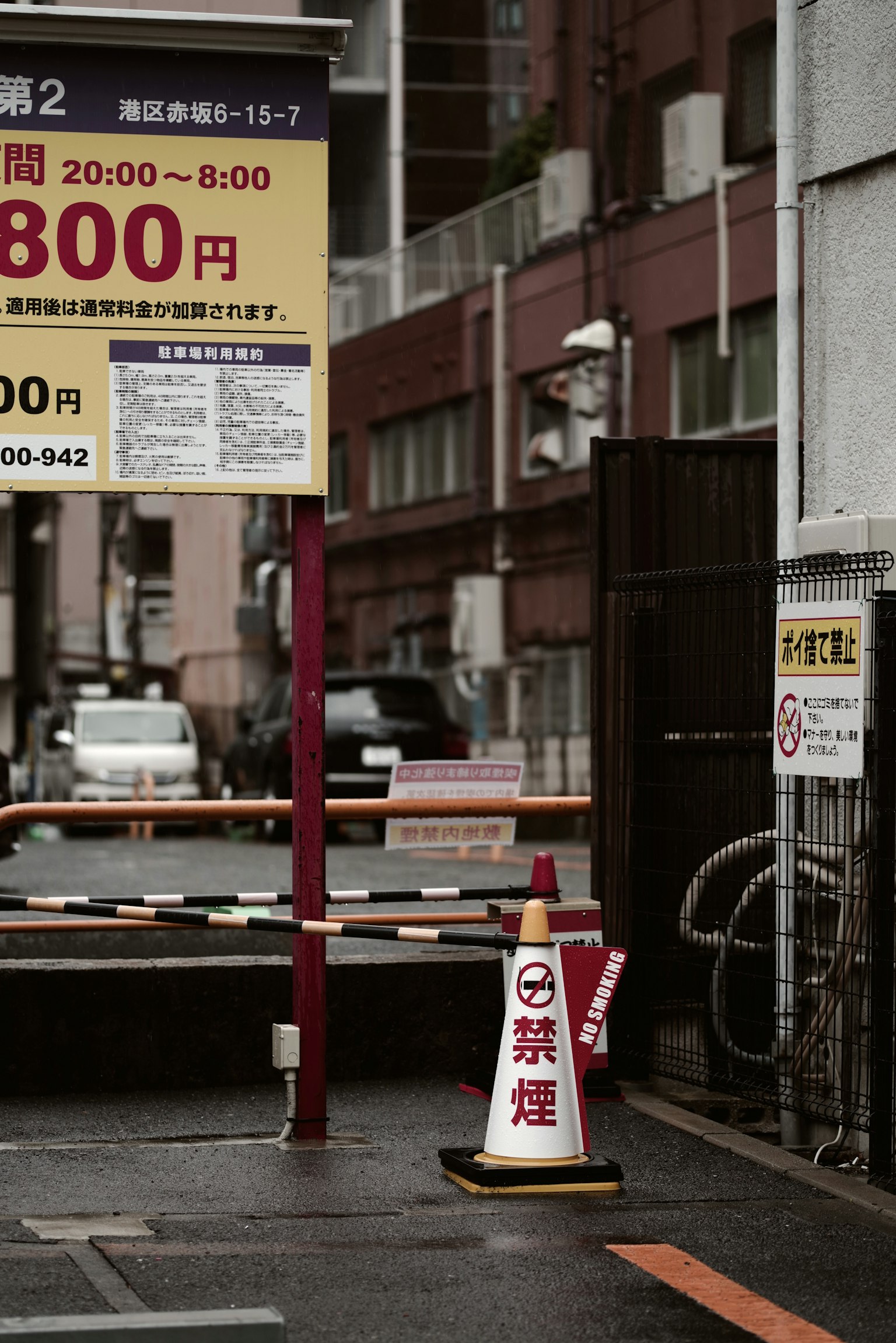 Urban scene featuring a parking fee sign and traffic cone