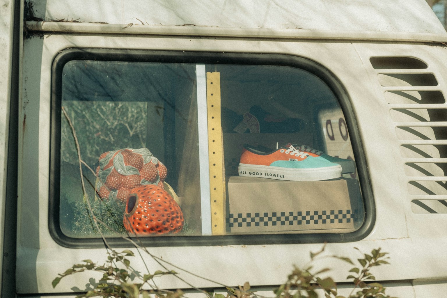 Image d'une fenêtre de camping-car avec un animal en peluche rouge et des baskets