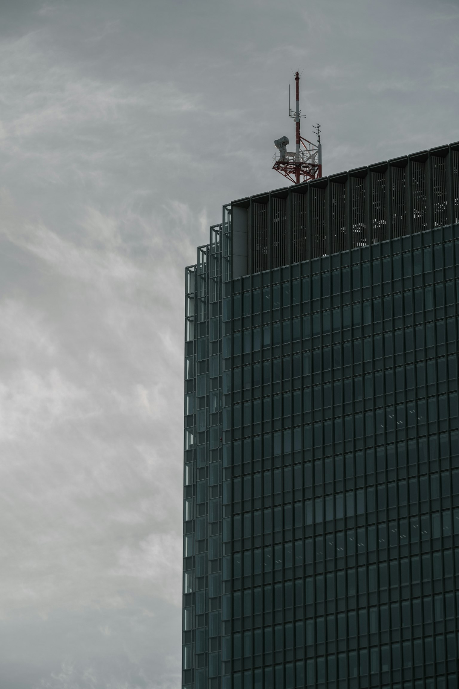 Section d'un gratte-ciel avec des antennes sur fond de ciel gris
