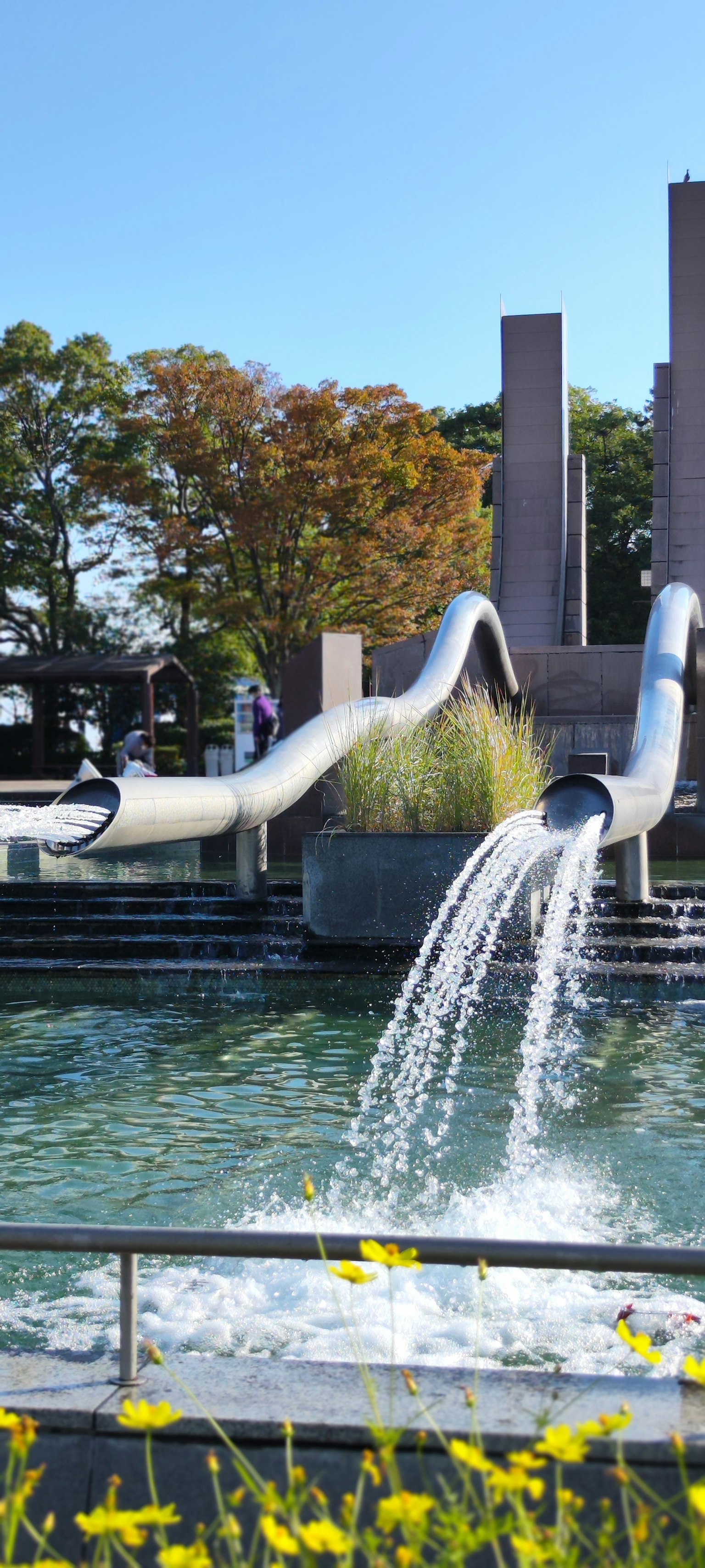 Une vue panoramique d'un parc avec une belle fontaine et de l'eau qui coule