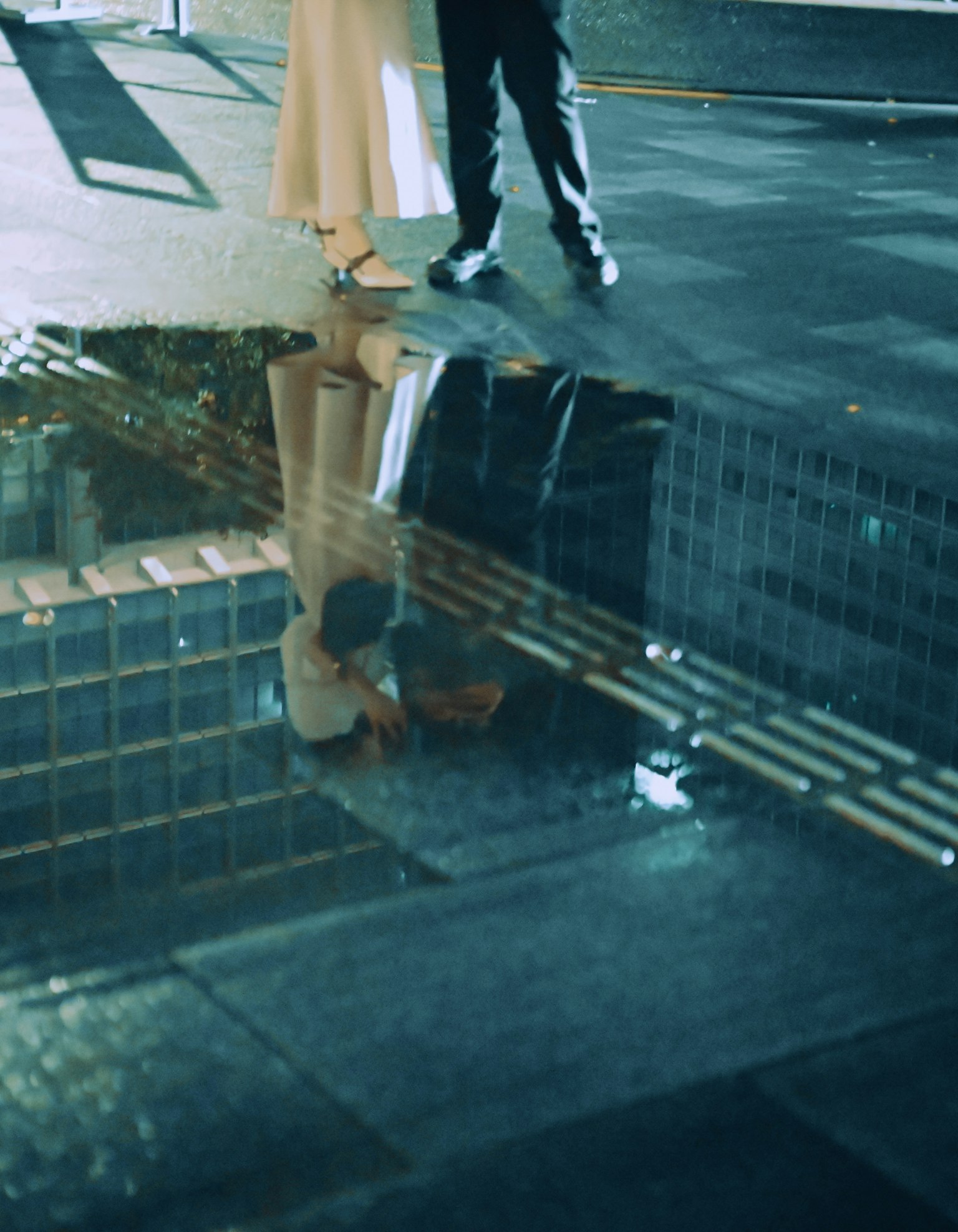 水洼中映出的情侶腳和城市風景