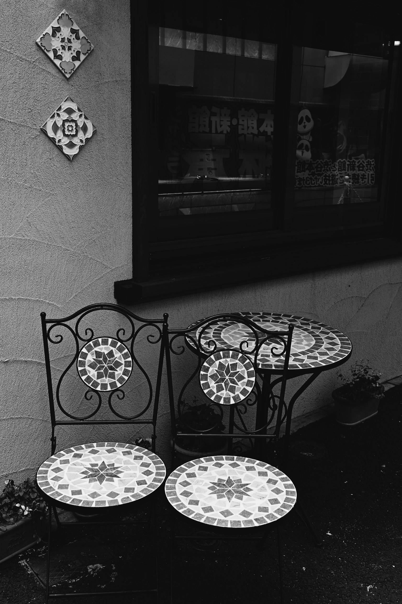 Decorative tiled table and chairs in a monochrome cafe exterior