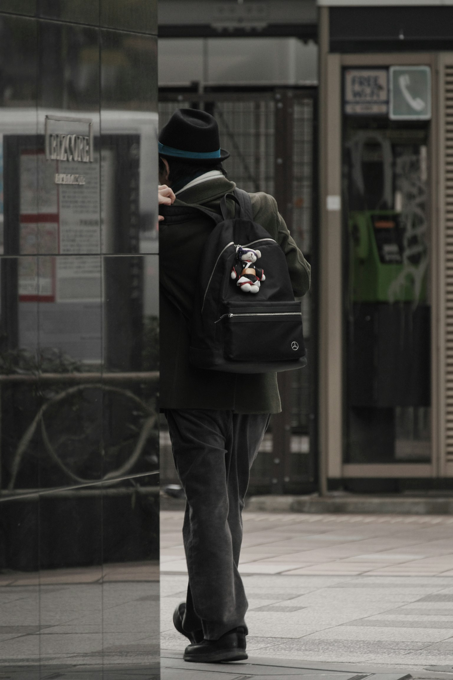 一个背着黑色背包的男人在城市中行走