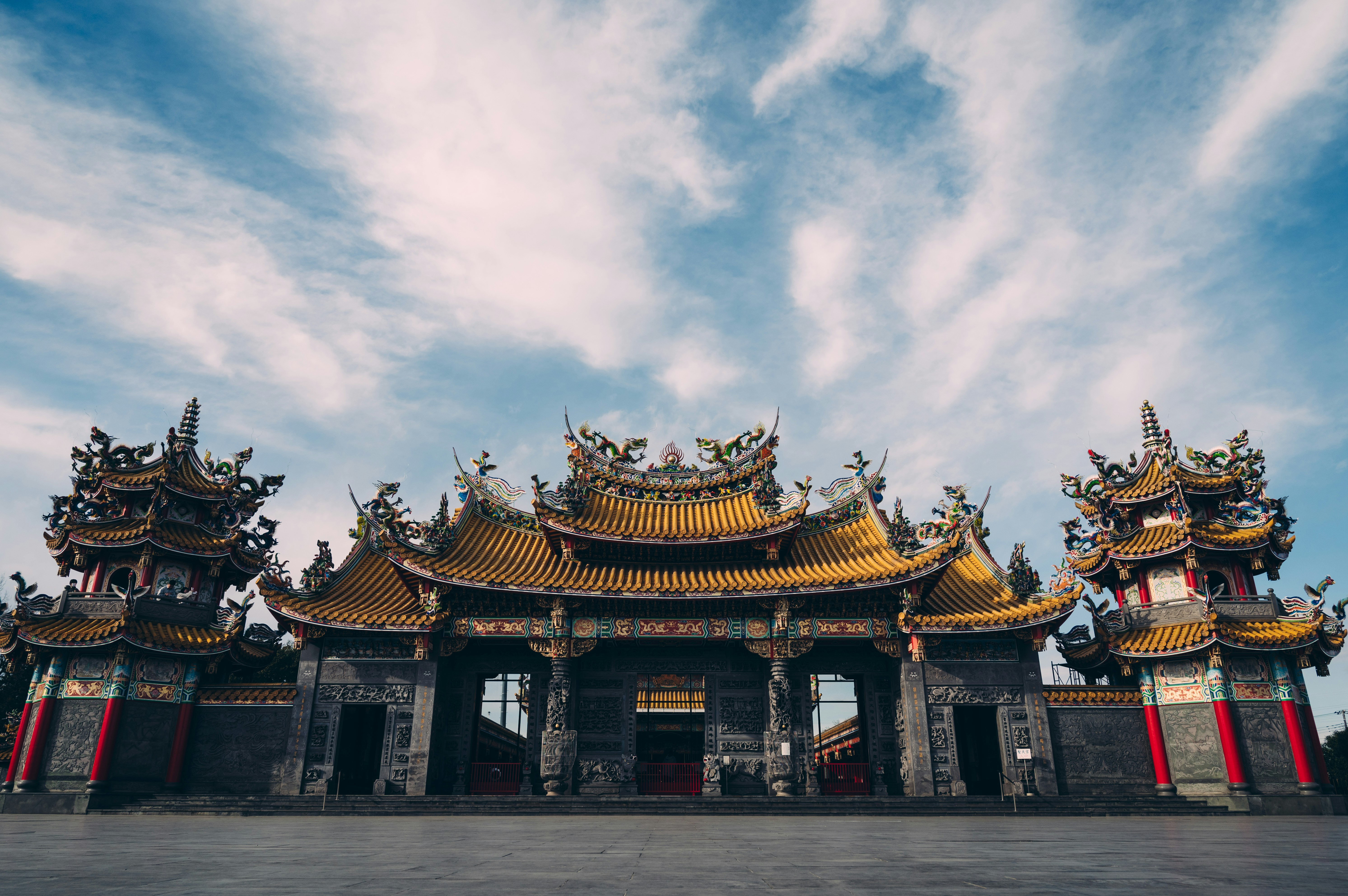 青空の下にそびえる伝統的な寺院の門と屋根