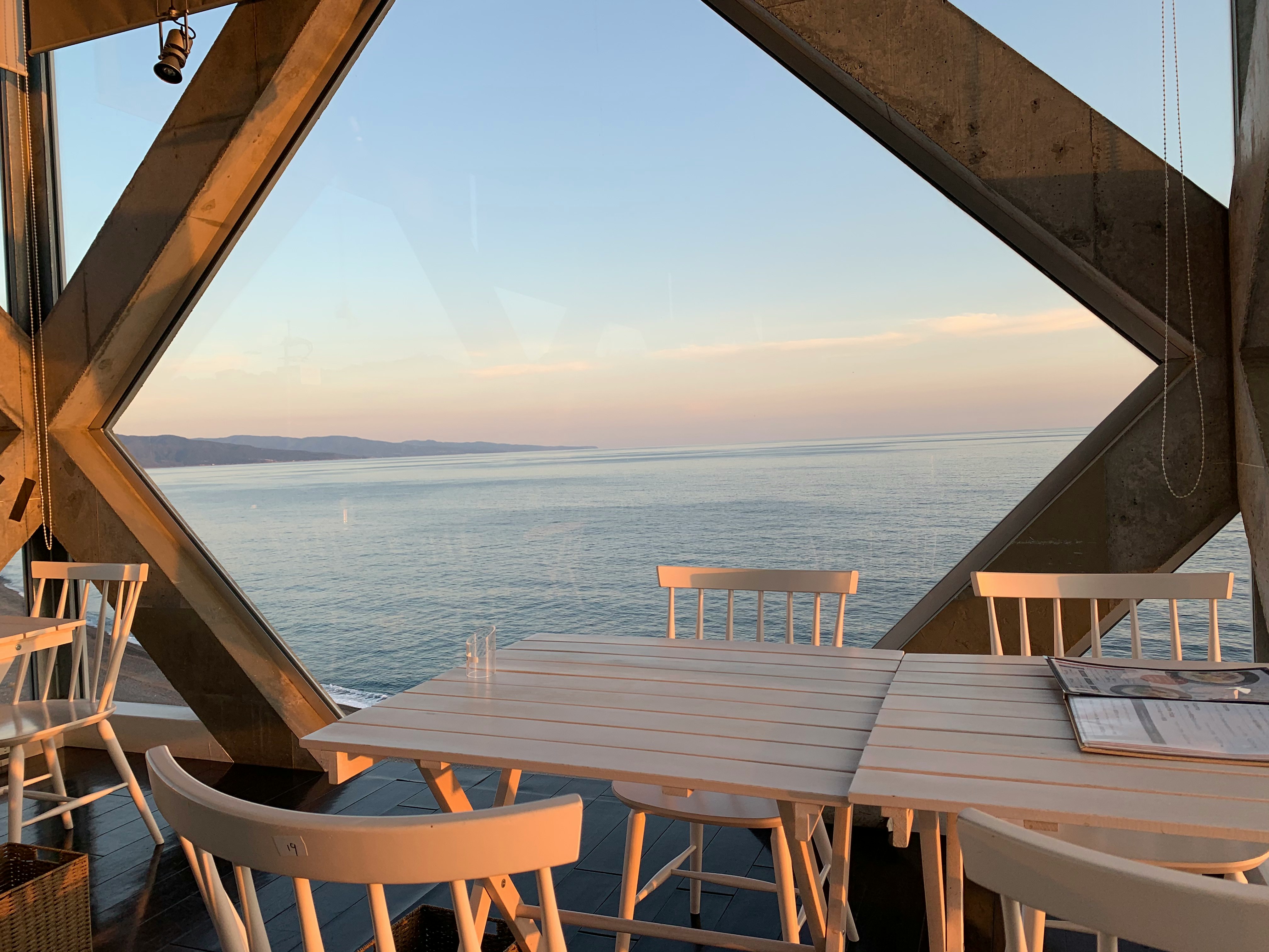 wooden table and chairs on an outdoor terrace overlooking the sea