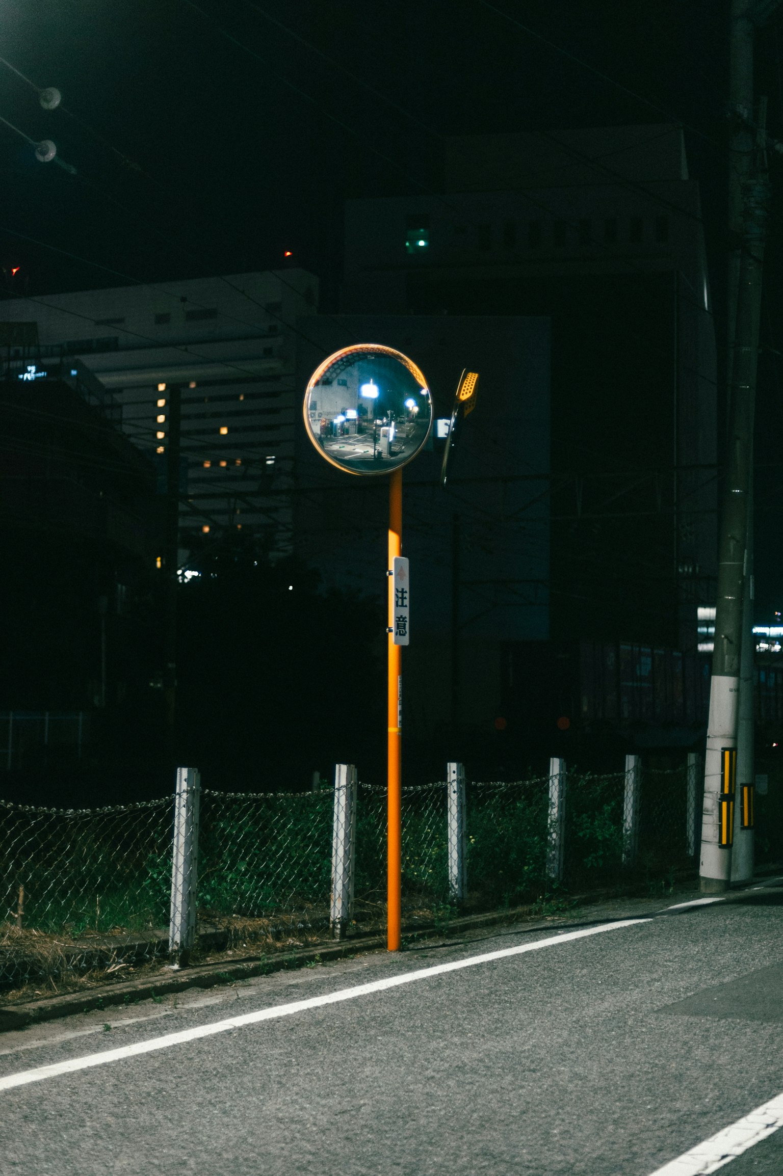 夜間路邊的橙色鏡子與城市背景