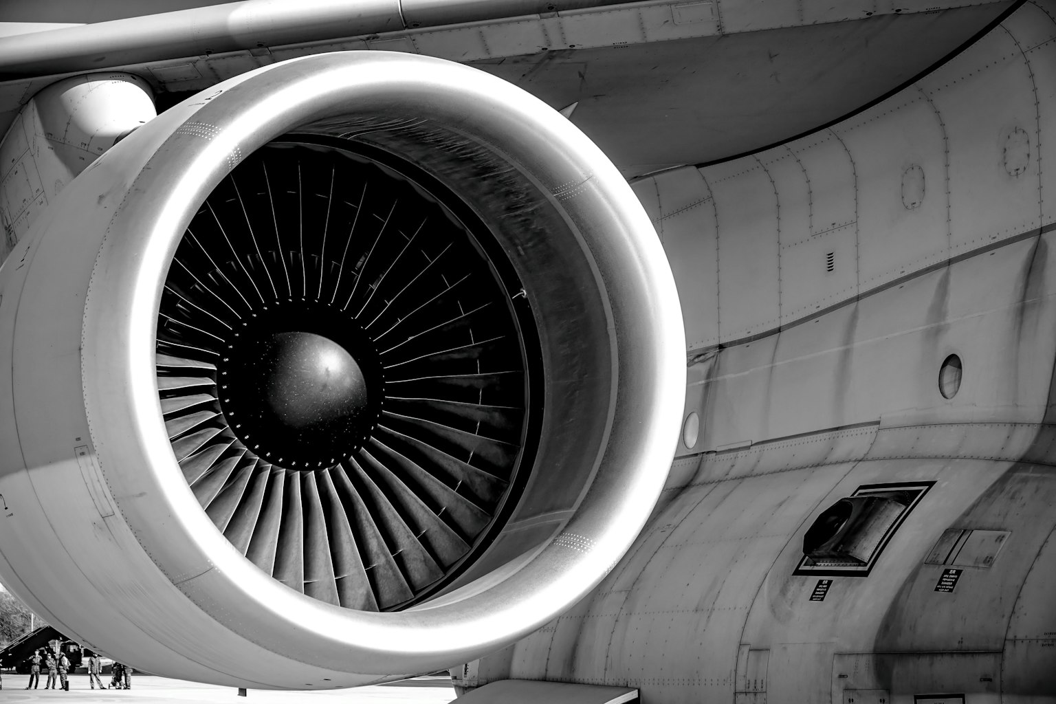 Nahaufnahme eines Flugzeugmotors in Schwarzweiß mit sichtbaren Ventilatorblättern