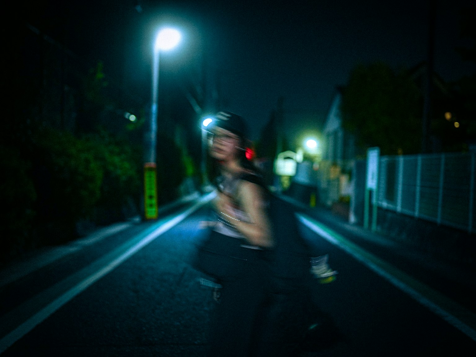 夜の街道を歩く人影と街灯の明かり