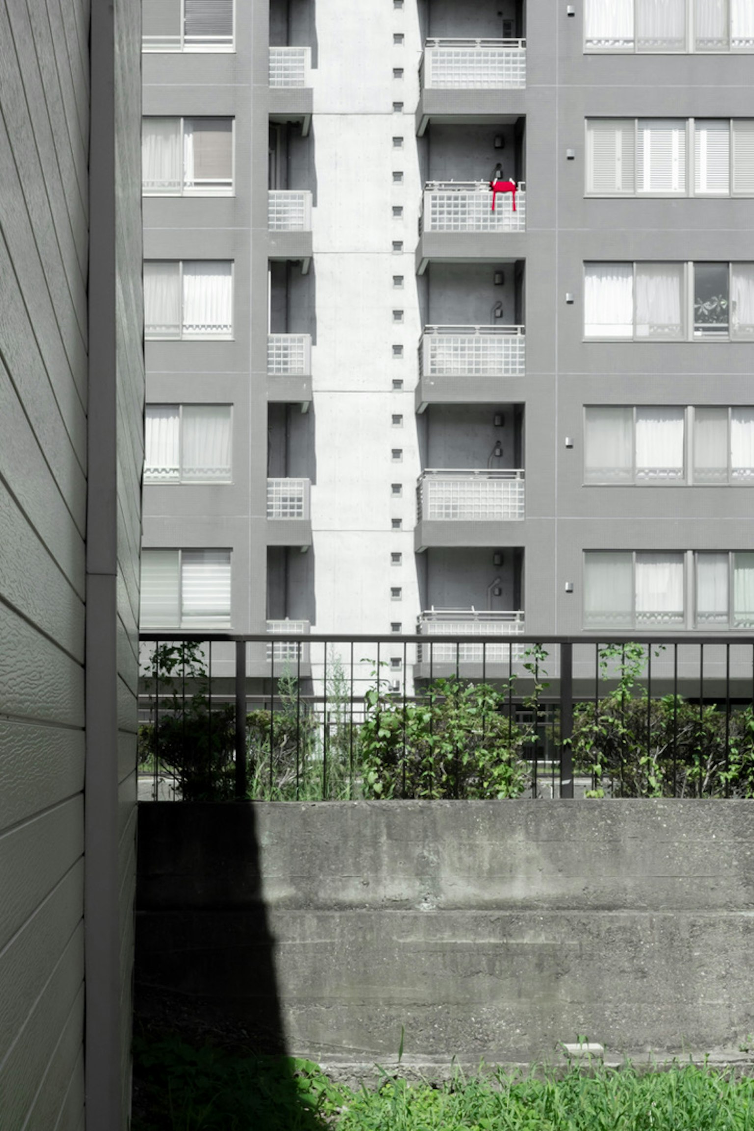 Gray apartment building with a green garden