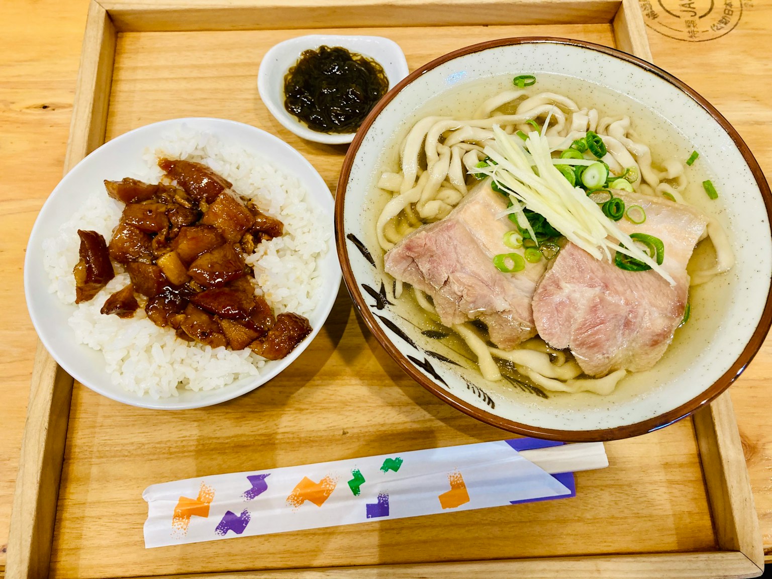 Udon con rodajas de cerdo servido con arroz y carne glaseada en salsa de soja dulce pequeño plato de salsa negra bandeja de madera