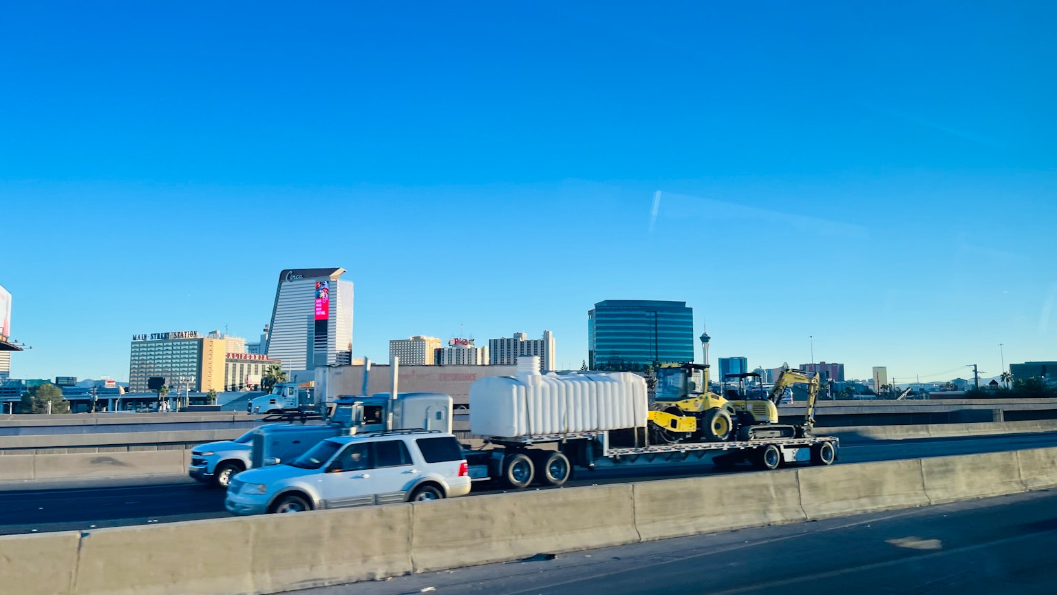 在晴朗蓝天下的高速公路场景，有拖车和汽车