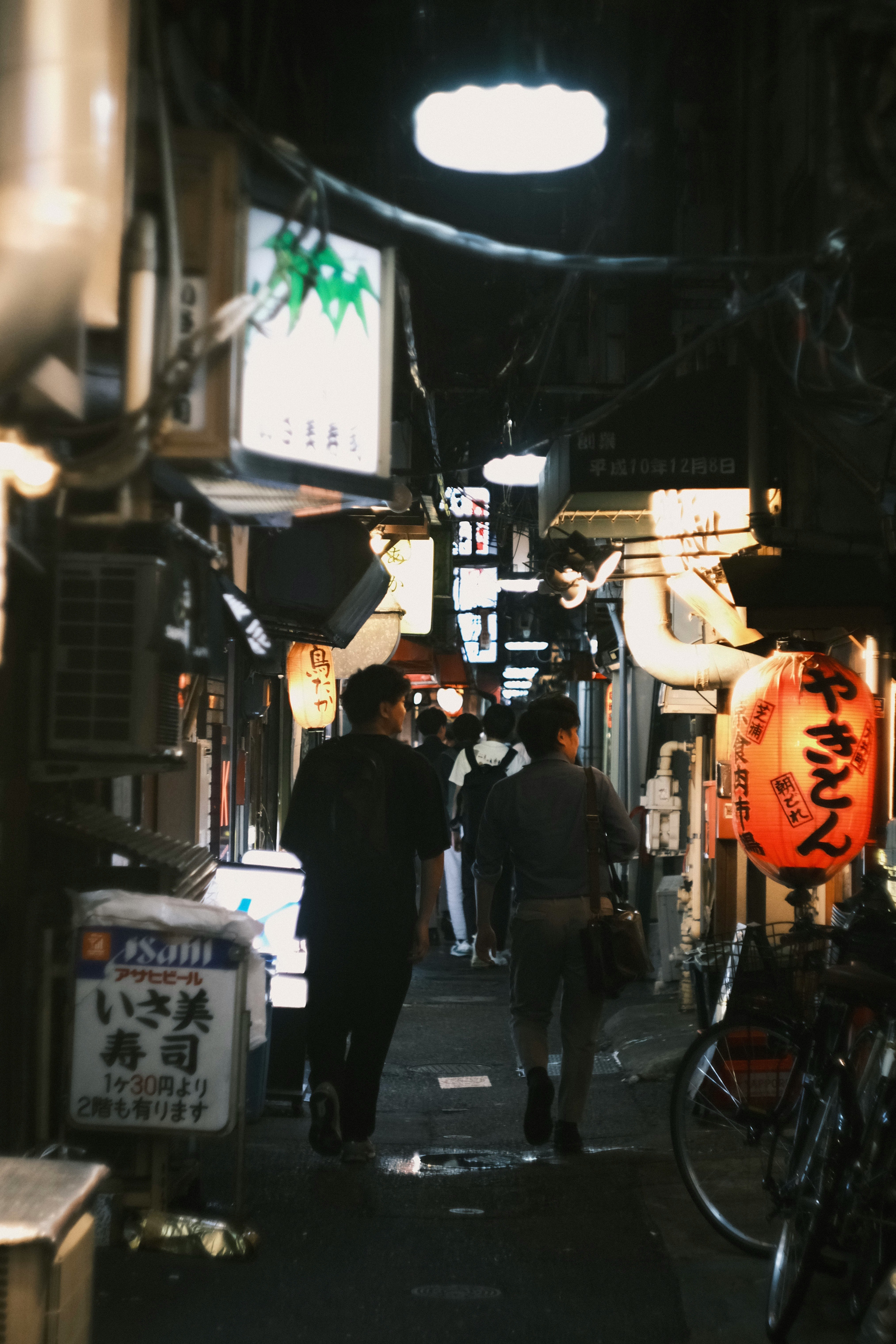 夜の路地に並ぶ提灯と人のいる商店街の通り