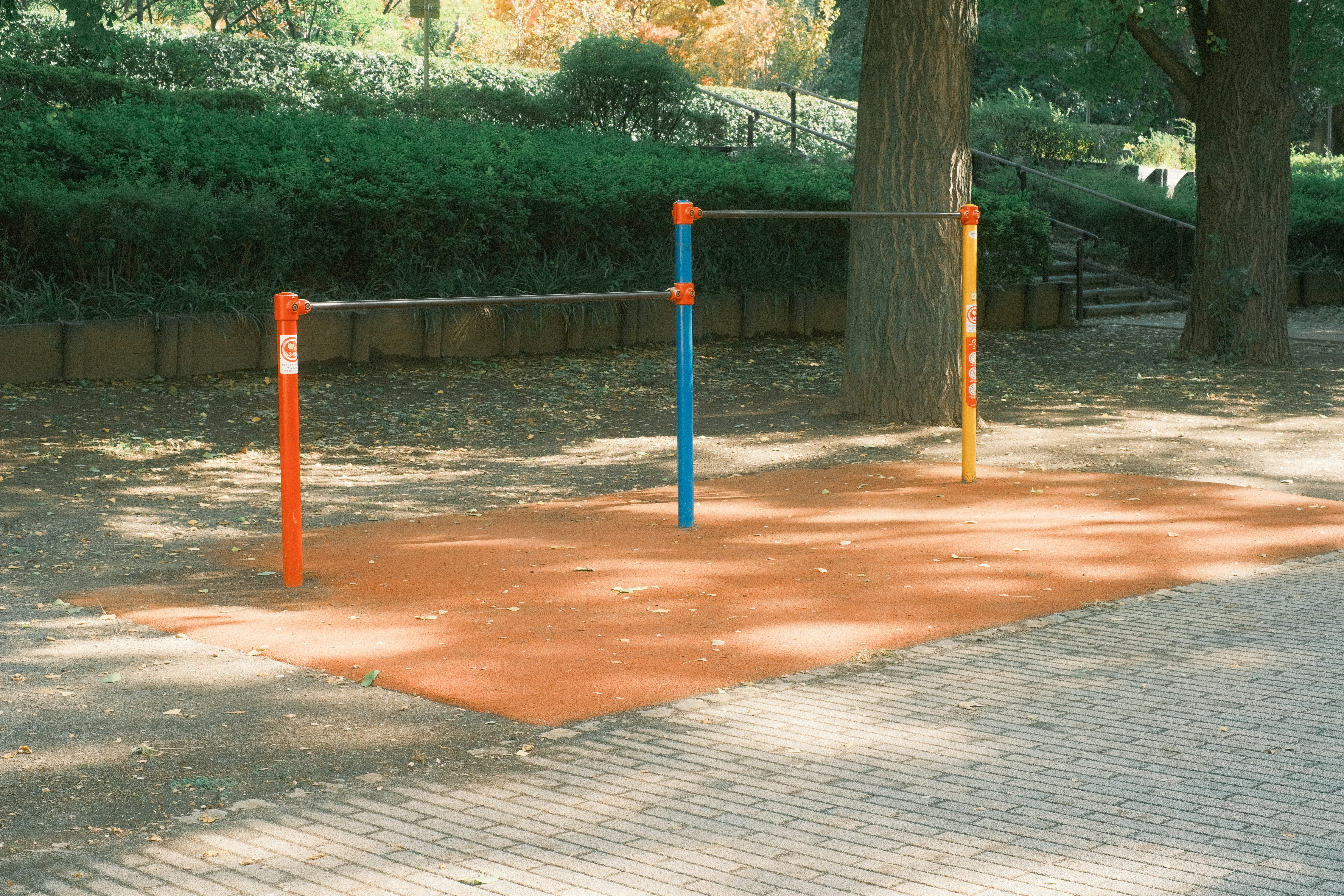 公園の遊具のあるレンガ敷きの小道