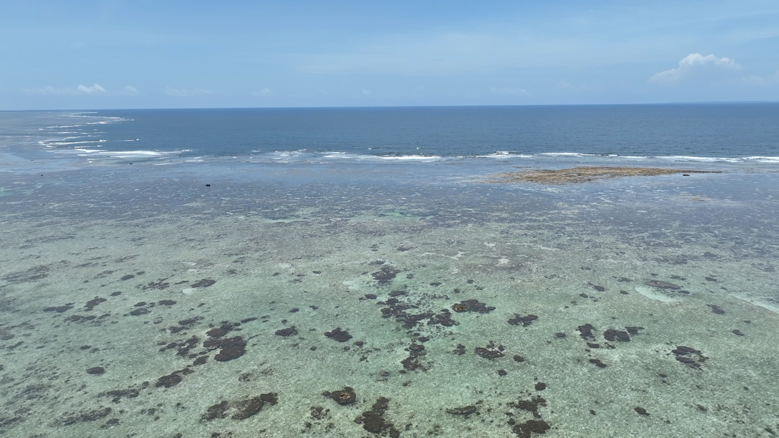 Pemandangan luas dari lautan biru jernih dan terumbu dangkal