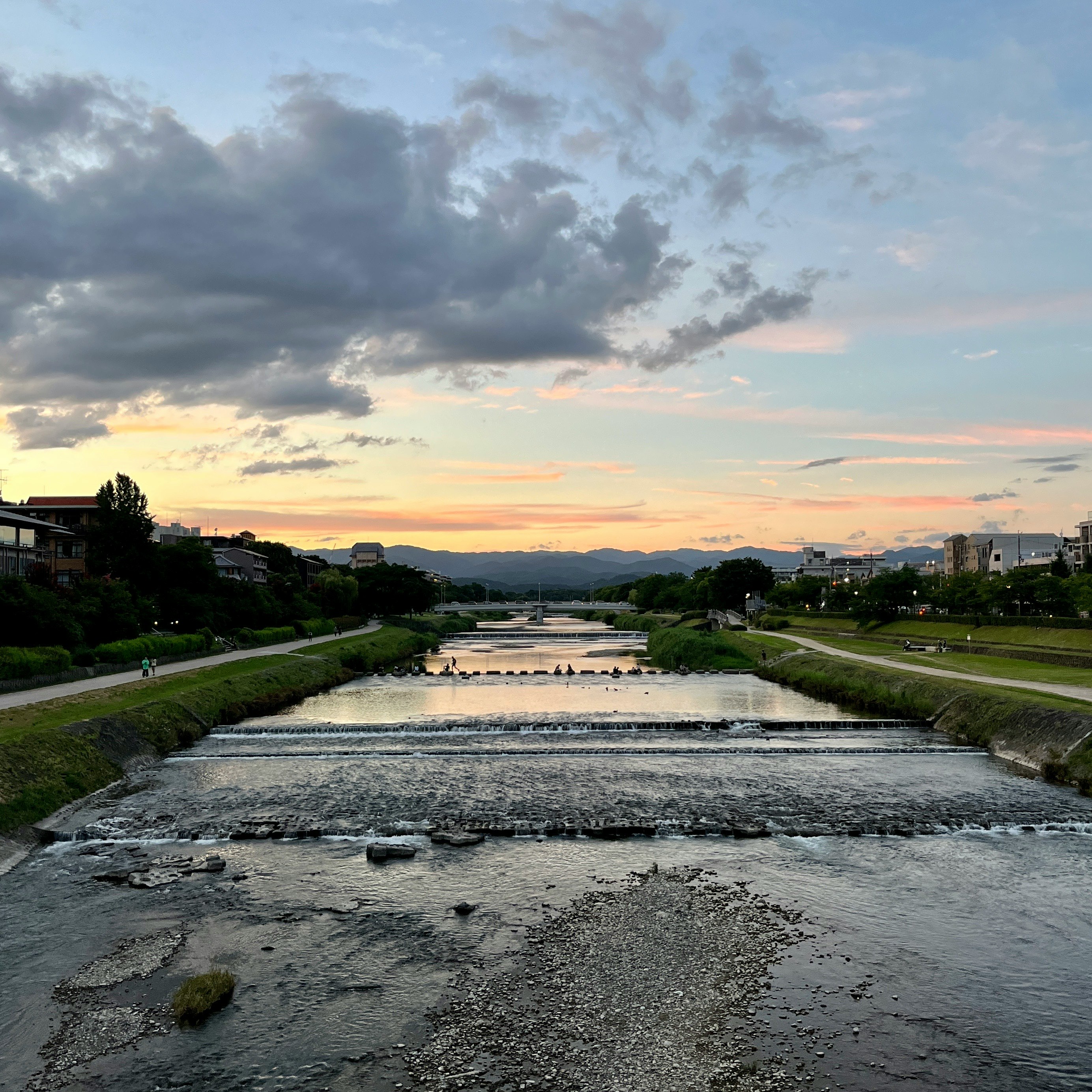 夕焼けの空と川沿いの公園・水路
