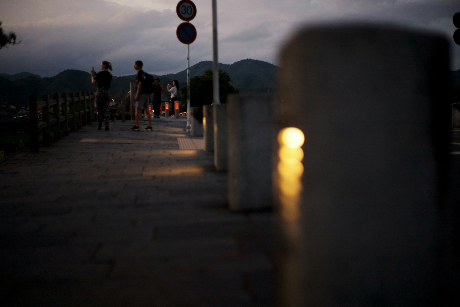 Persone che camminano su un sentiero poco illuminato con lampioni