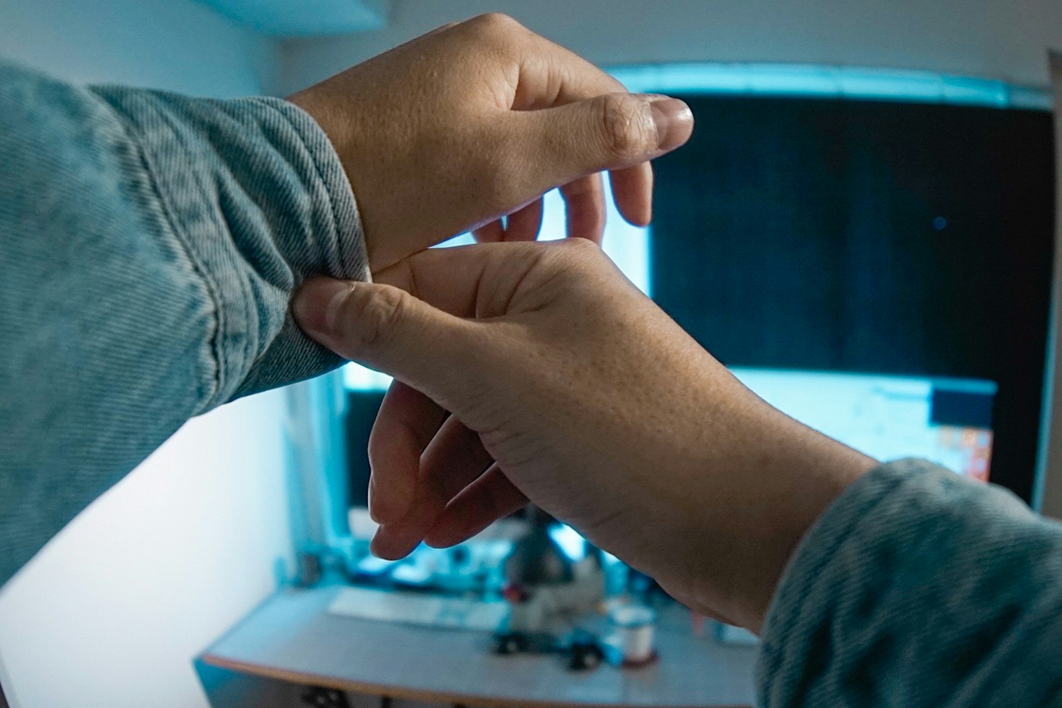 Nahaufnahme einer Person, die ihr Handgelenk in einem gestalteten Raum anpasst