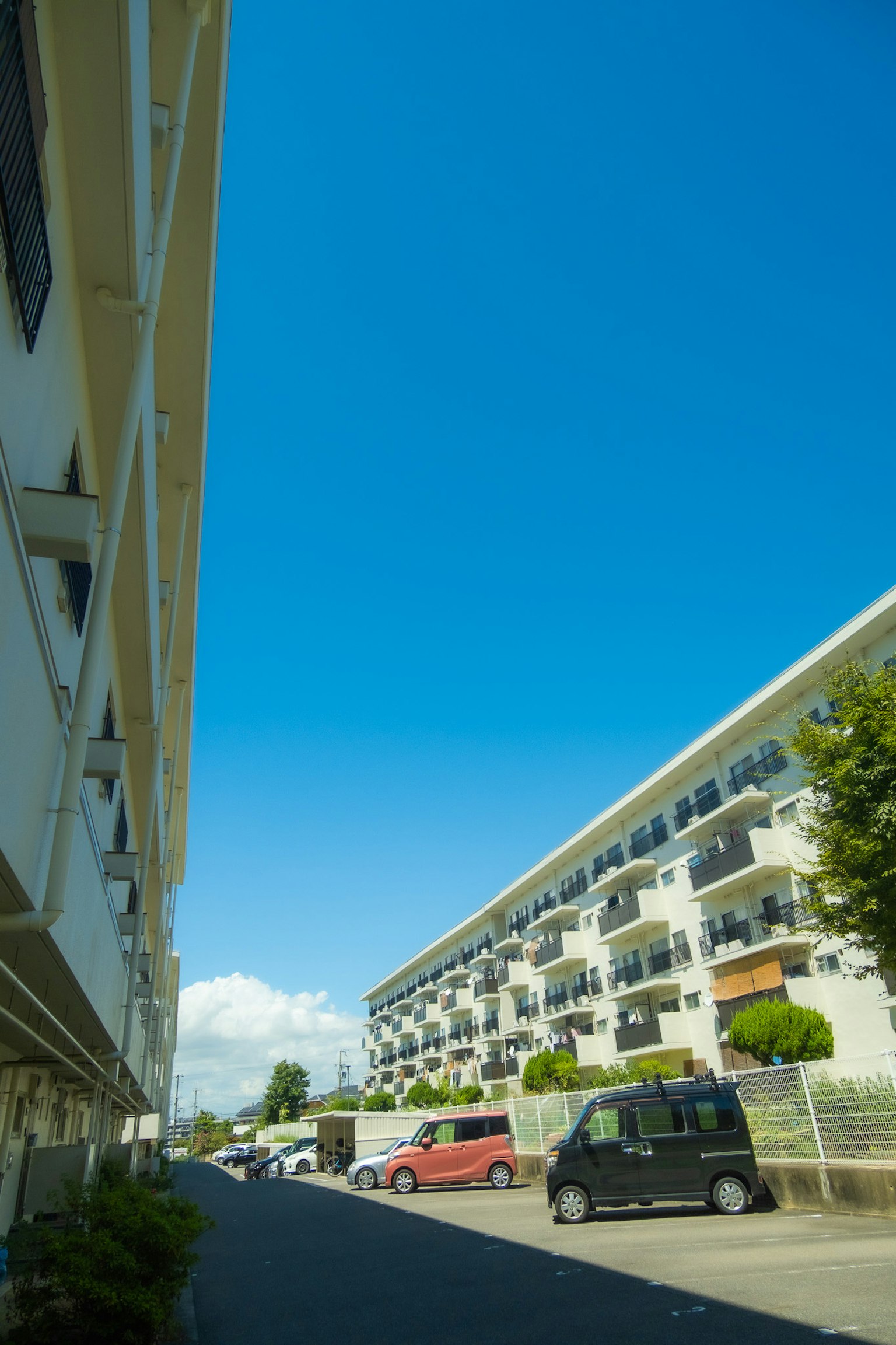 Vista di edifici residenziali e area di parcheggio sotto un cielo blu chiaro