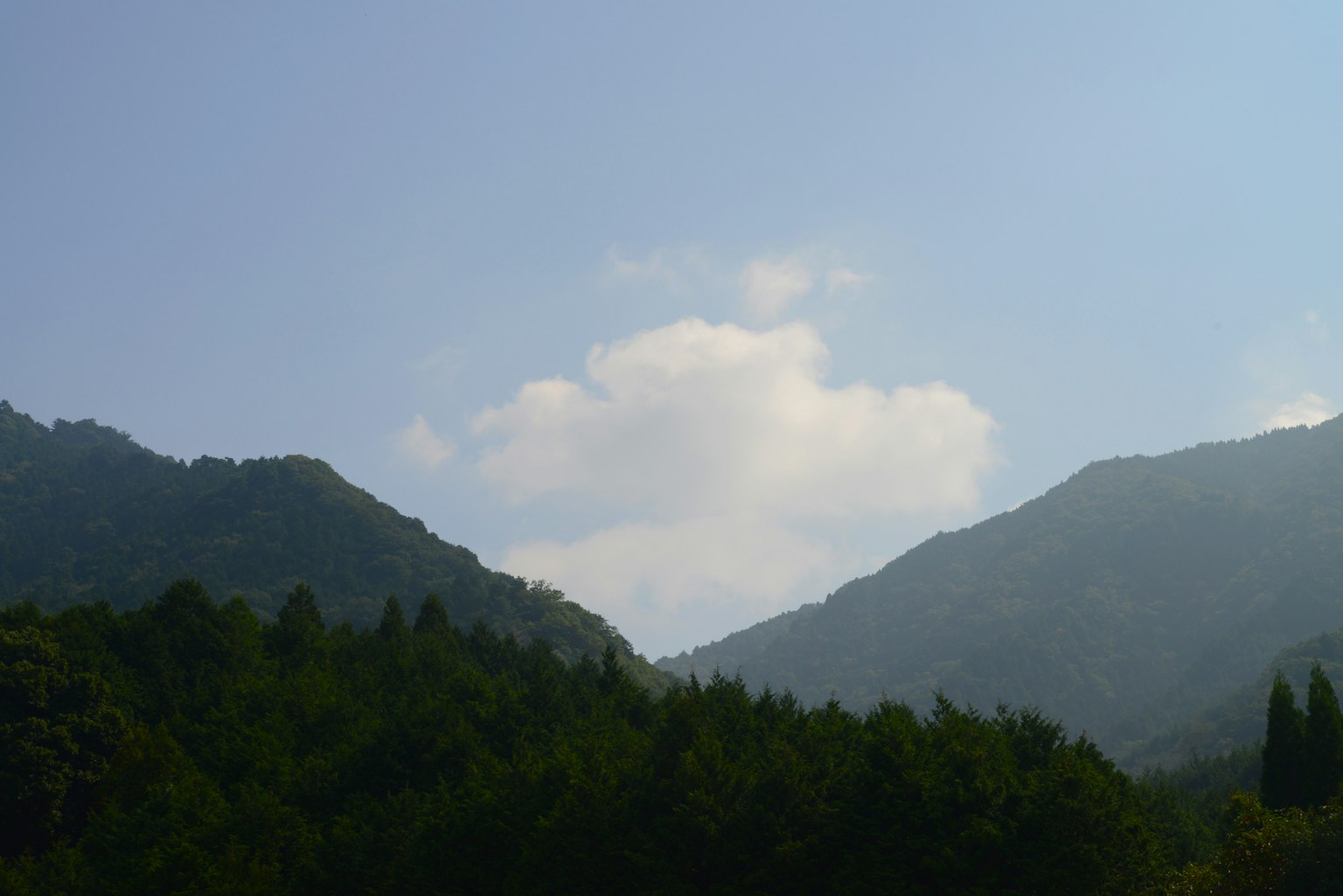 Pemandangan pegunungan dengan langit biru dan awan putih