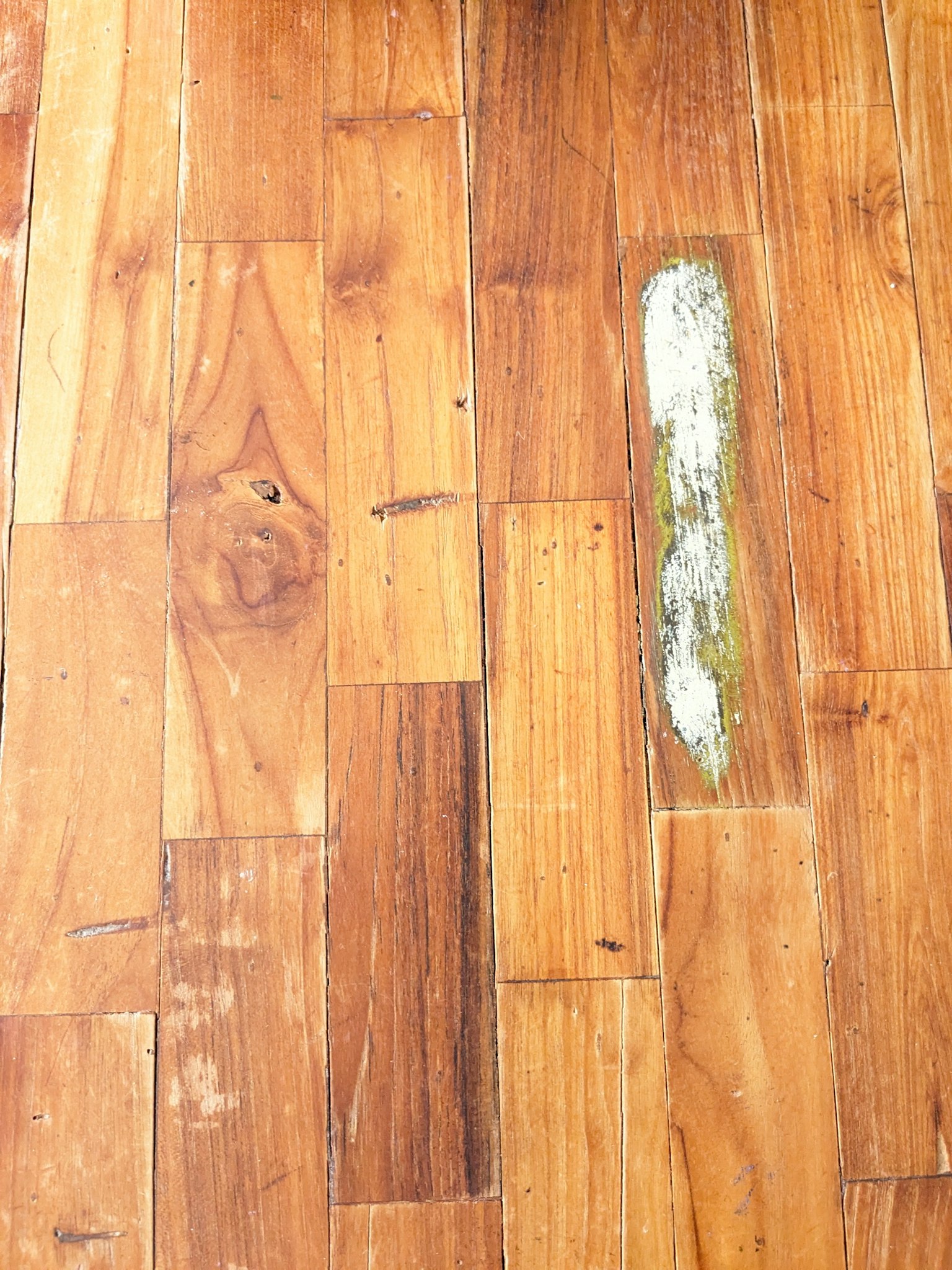 Wooden floor surface with a white stain