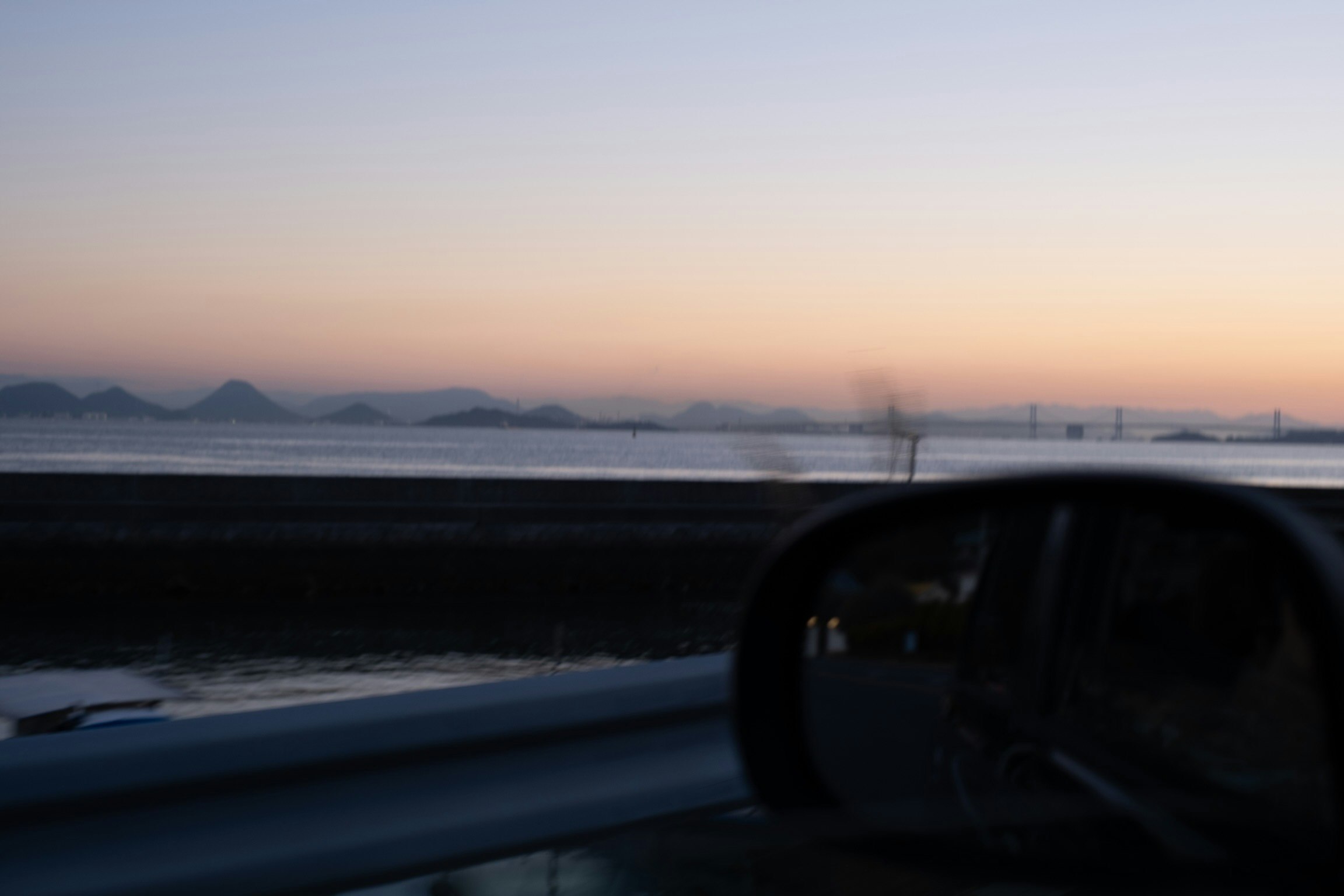 car driving along a seaside at dusk
