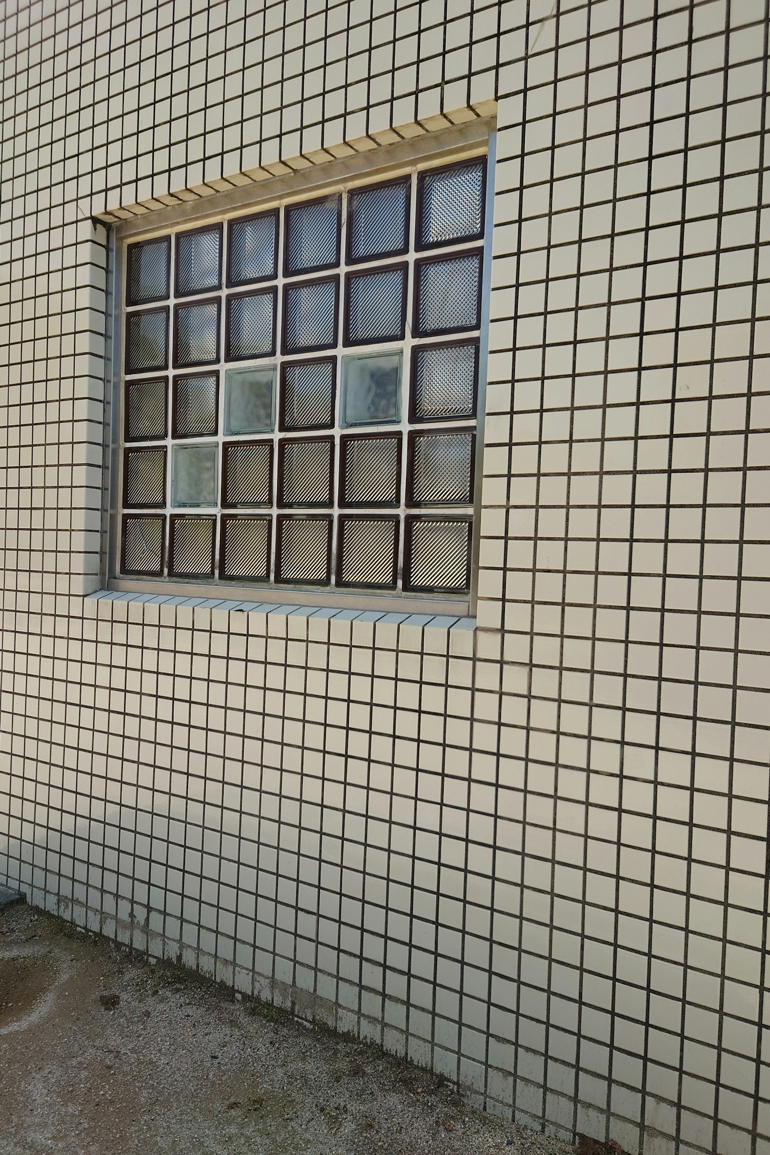 Glass block window set in a white tiled wall