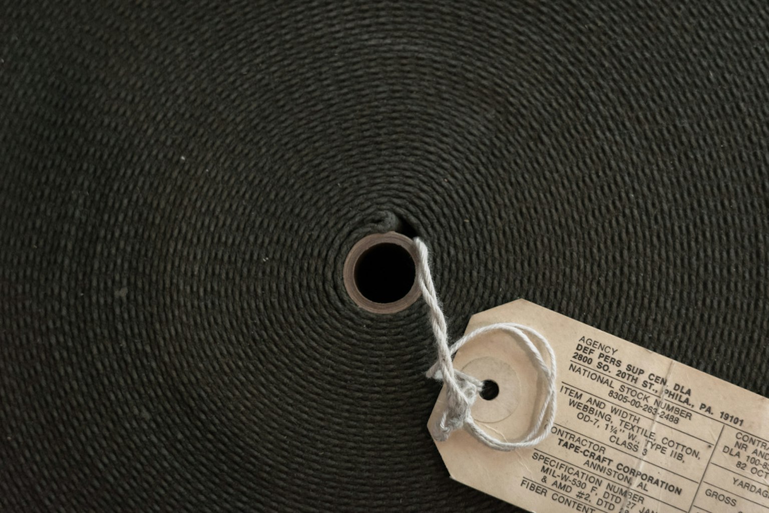 Gros plan d'un rouleau vert avec un trou central et une étiquette attachée