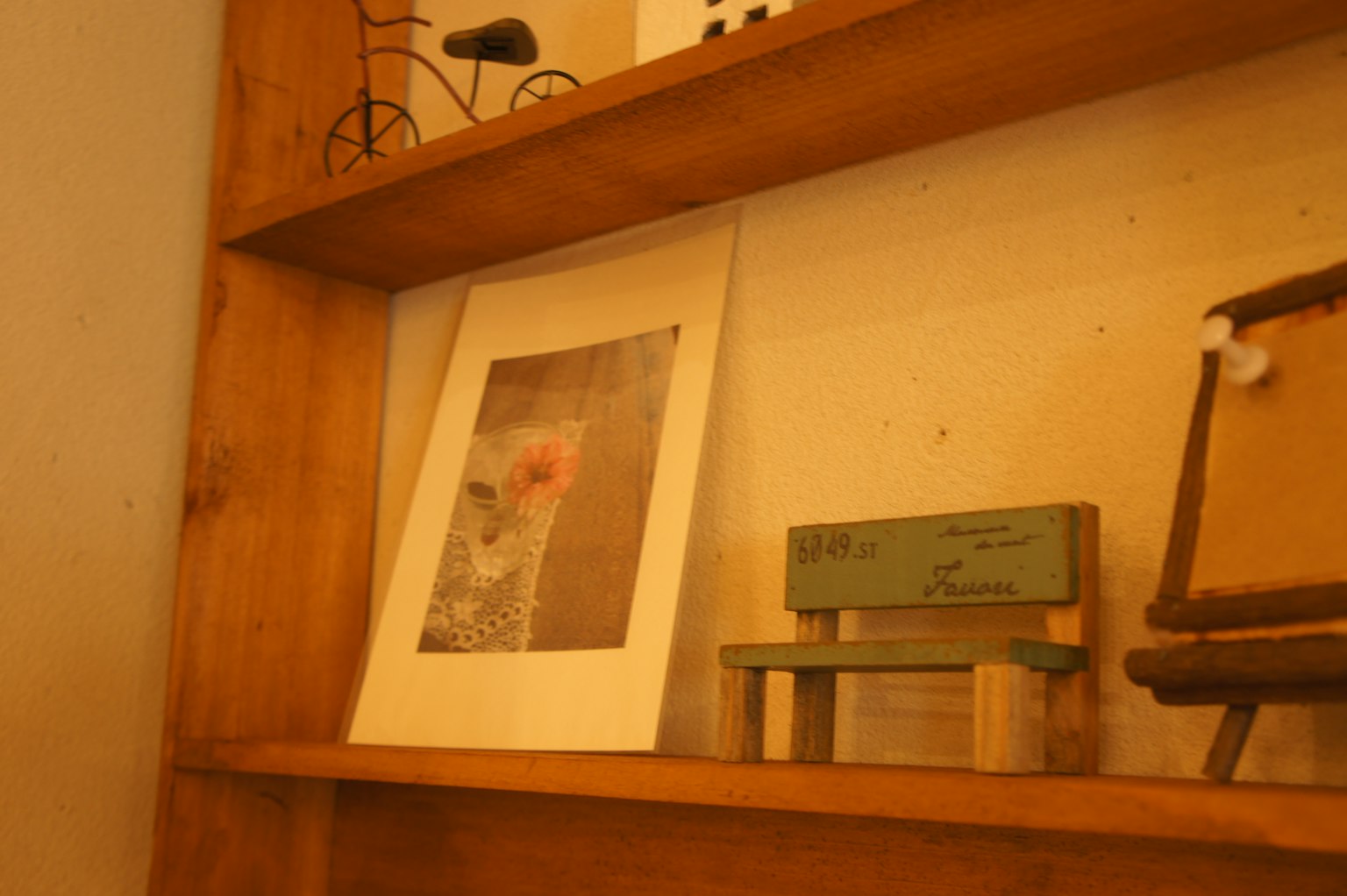 Stampa artistica e piccolo banco di legno su una mensola di legno
