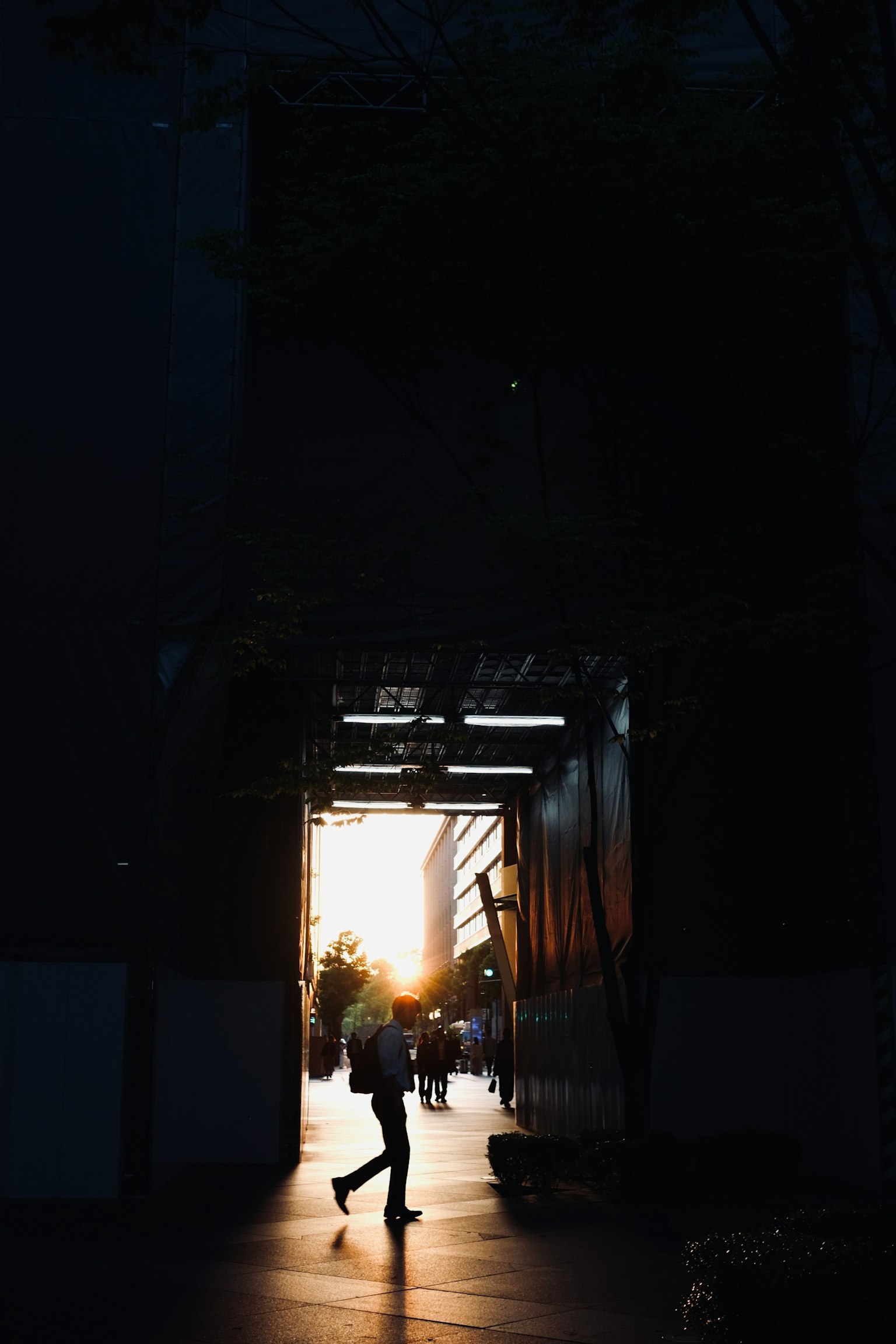 走过黑暗通道的人与夕阳光