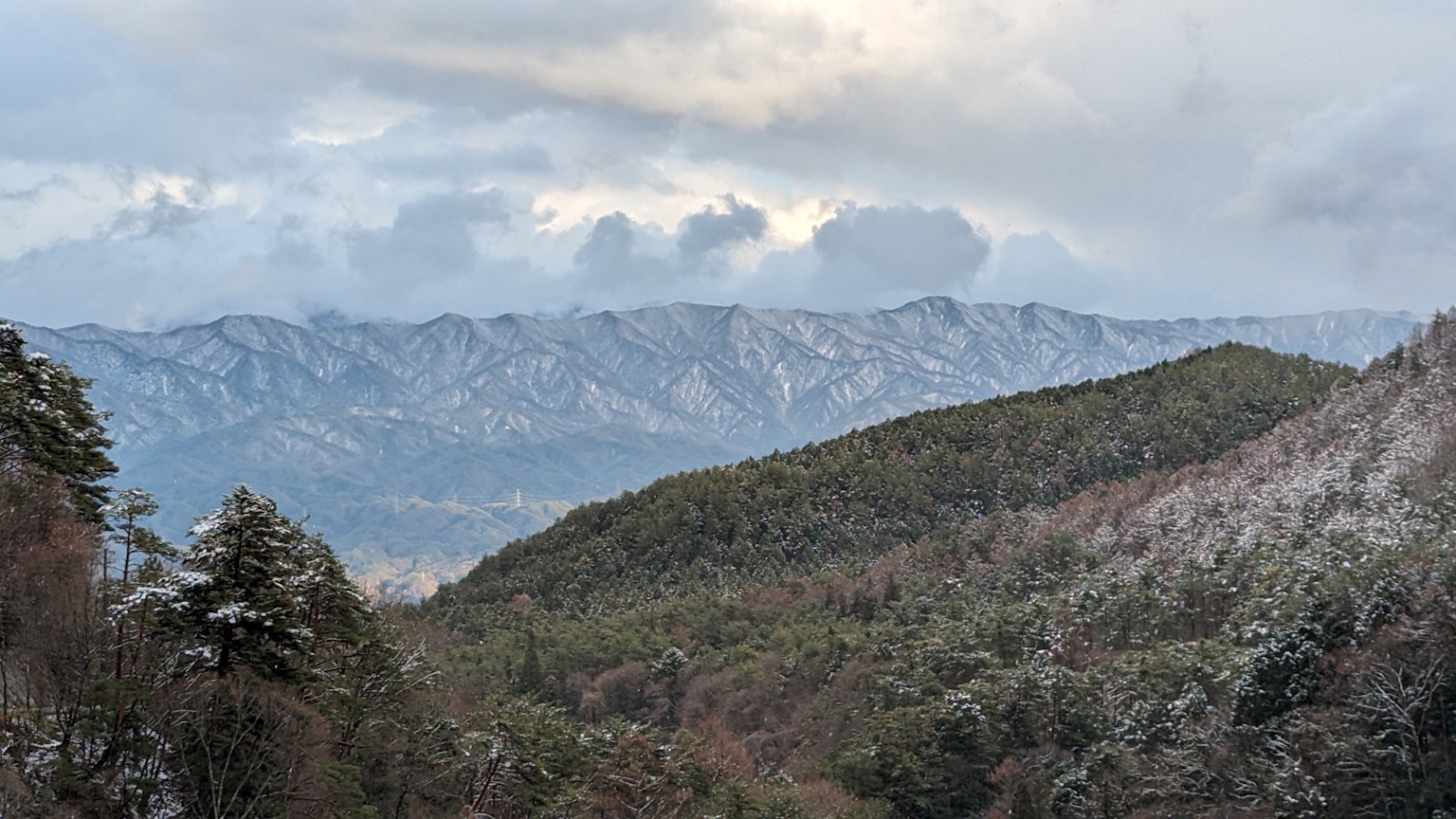 Vista panoramica di montagne innevate e colline verdi