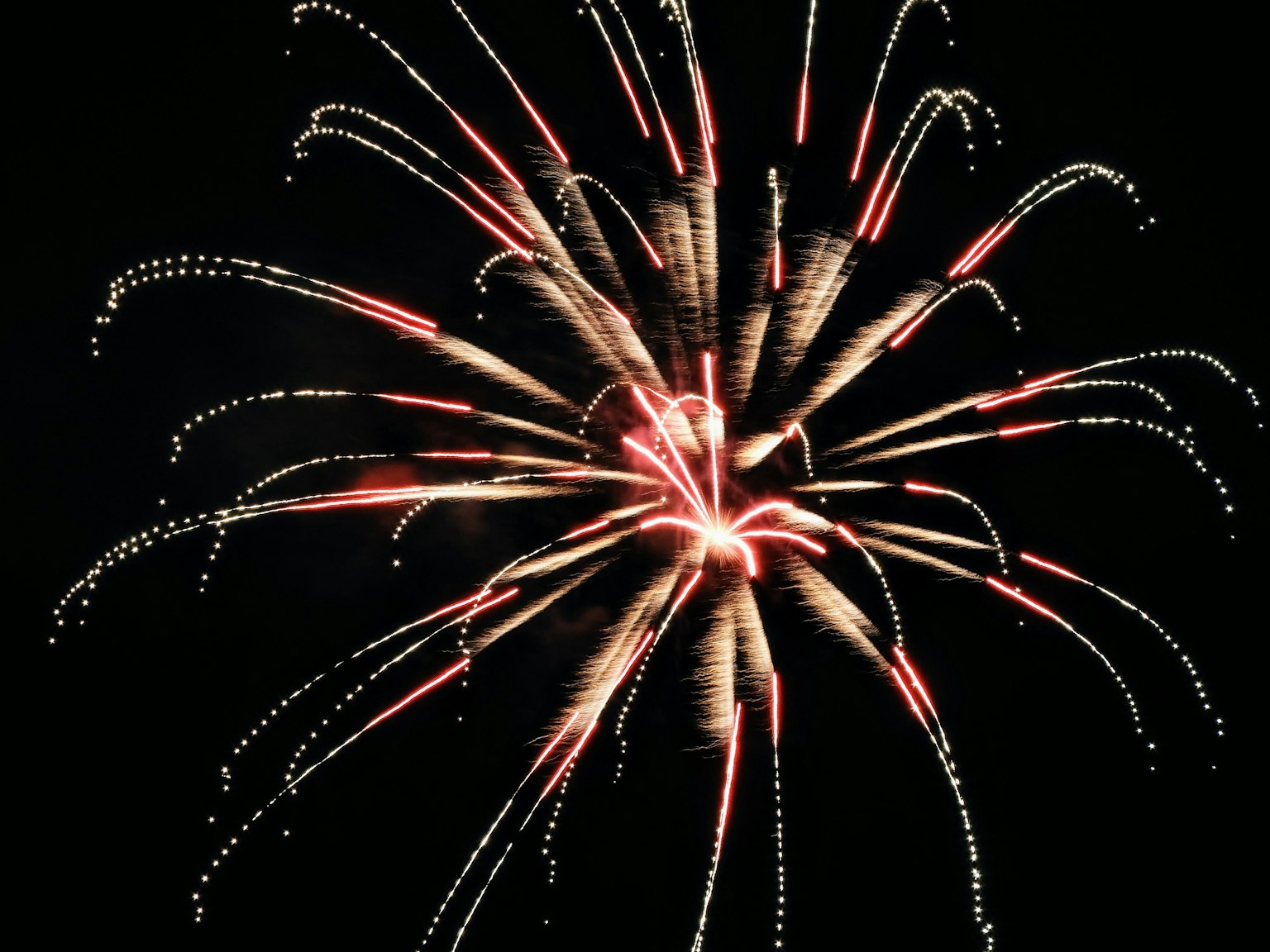 Hermosa explosión de fuegos artificiales en el cielo nocturno Luces rojas y blancas estallando