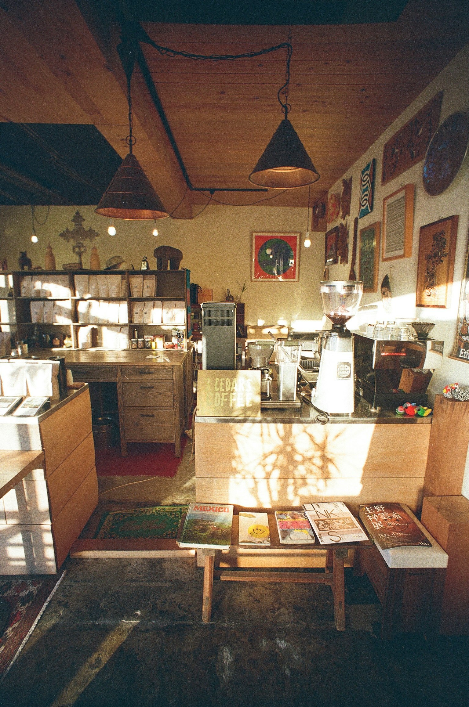 Warm interior of a cafe featuring wooden counter and art-covered walls