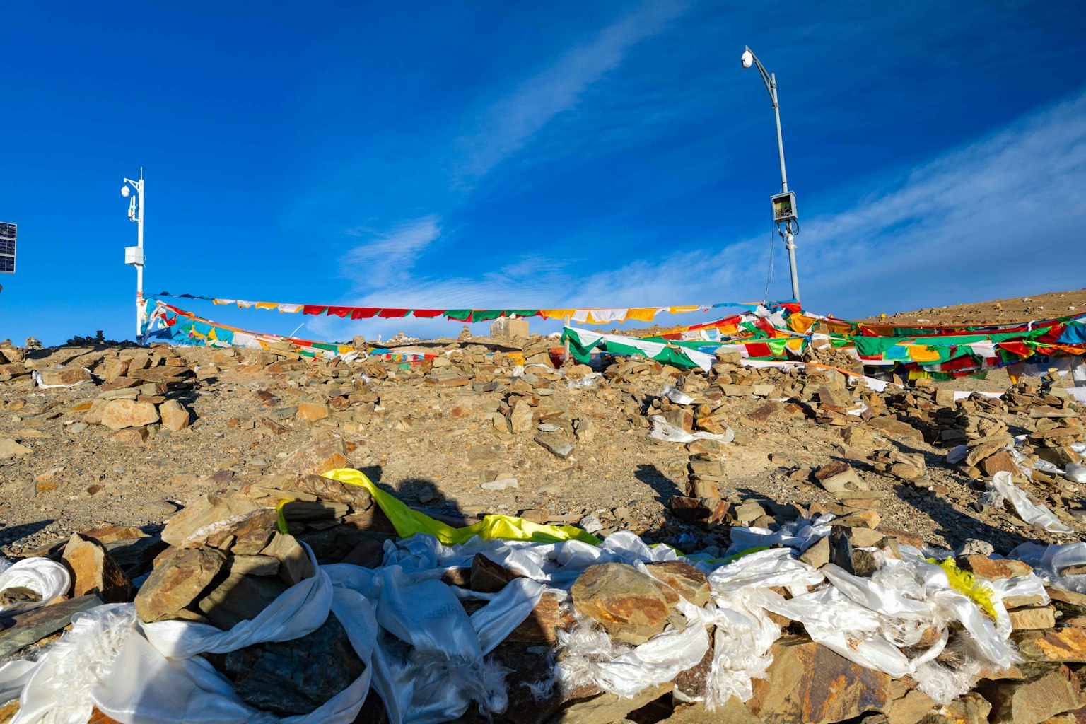 Scenic view of a rocky terrain with scattered waste under a blue sky