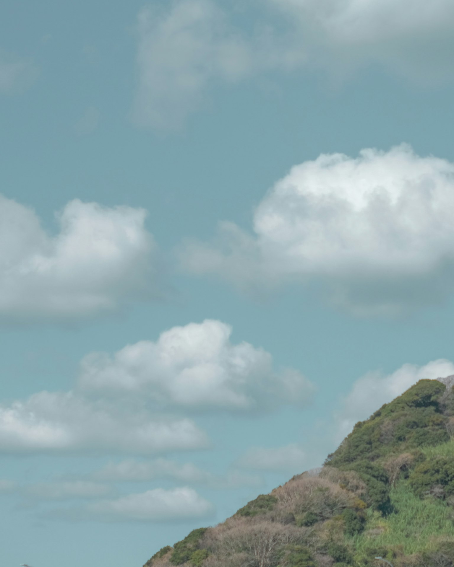 Cielo azul con nubes blancas y colinas verdes