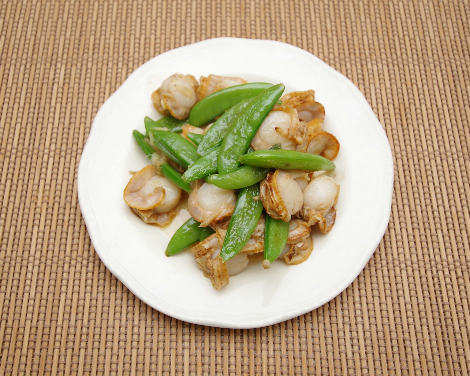 Hidangan udang dan kacang polong di piring putih