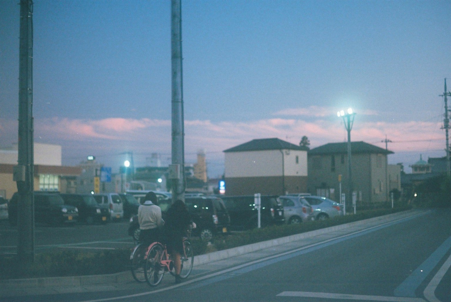 Paisaje urbano al atardecer con personas en bicicleta