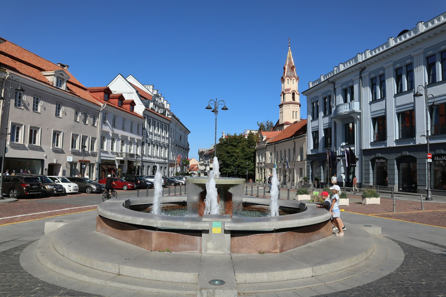 Schöne Fontäne mit historischen Gebäuden an der Straße