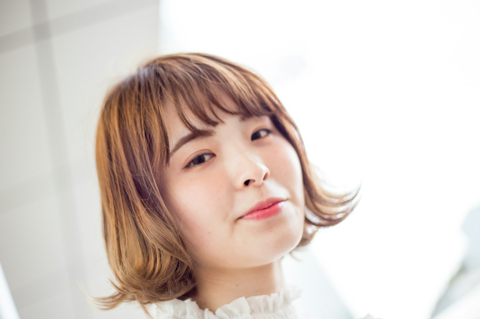 年轻女性微笑的肖像，背景明亮