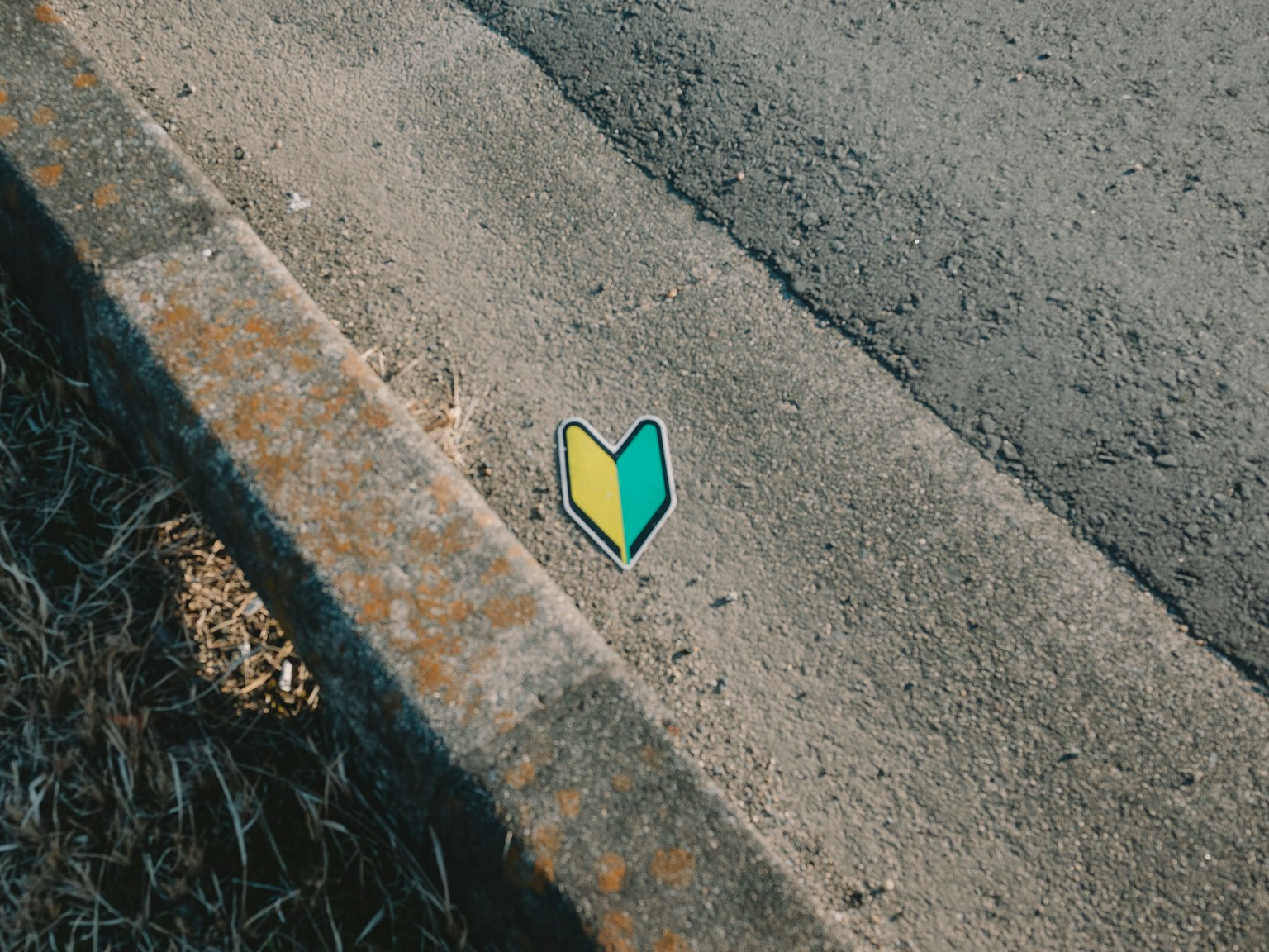 Tanda berbentuk hati hijau dan kuning di tepi jalan