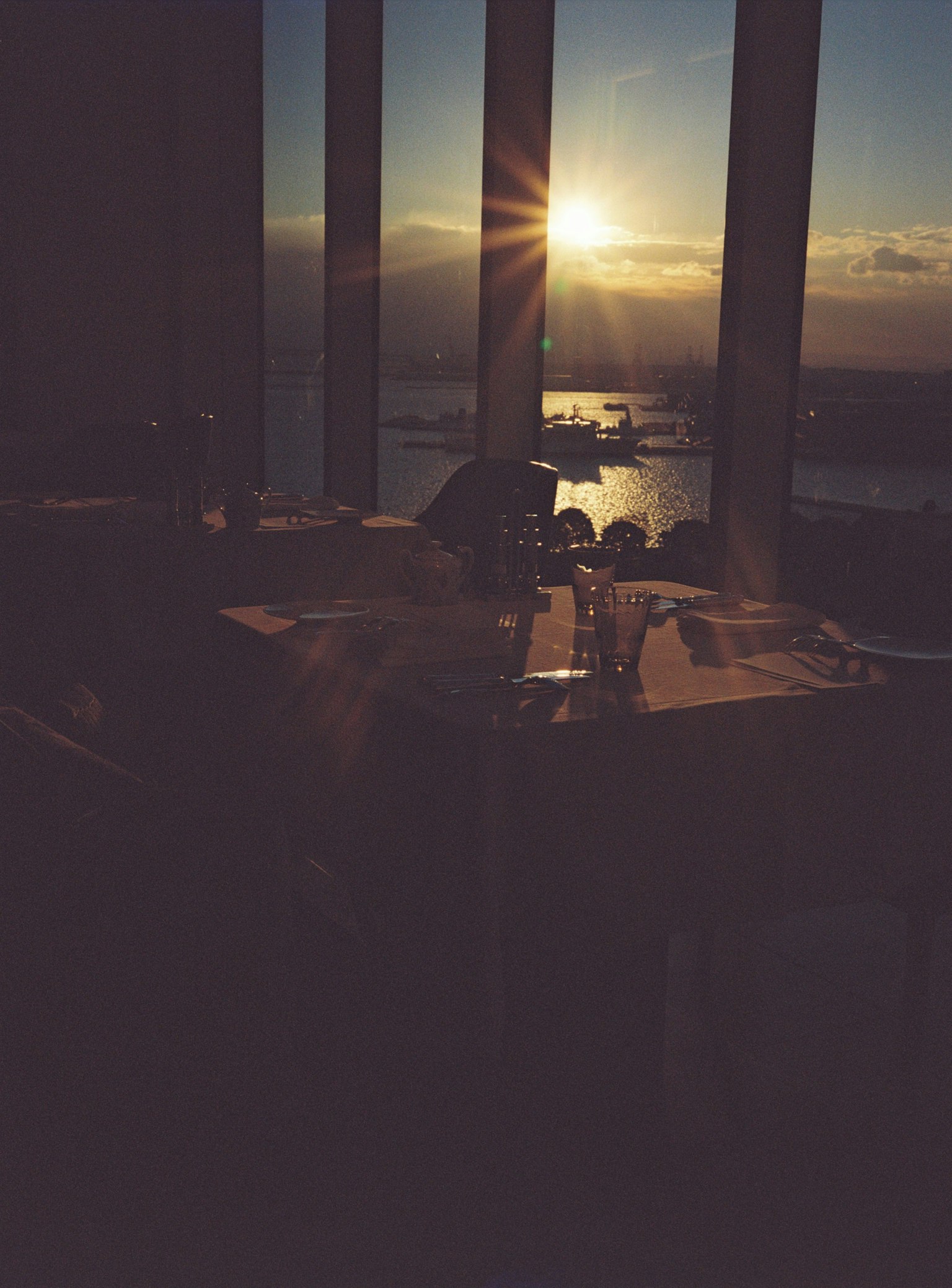 Vista di un ristorante con il tramonto sull'oceano attraverso grandi finestre