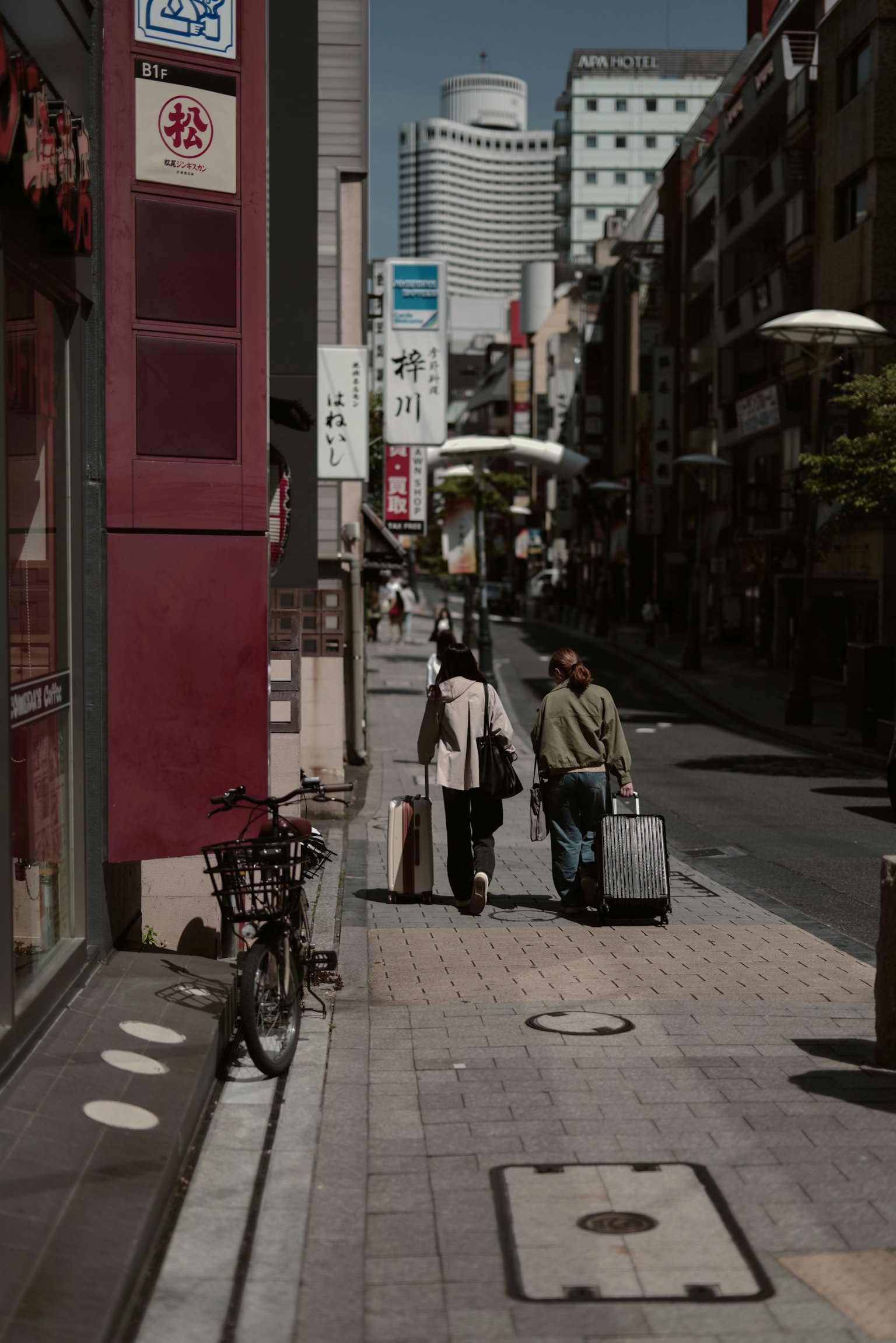 Dos personas caminando por una calle de la ciudad con edificios circundantes