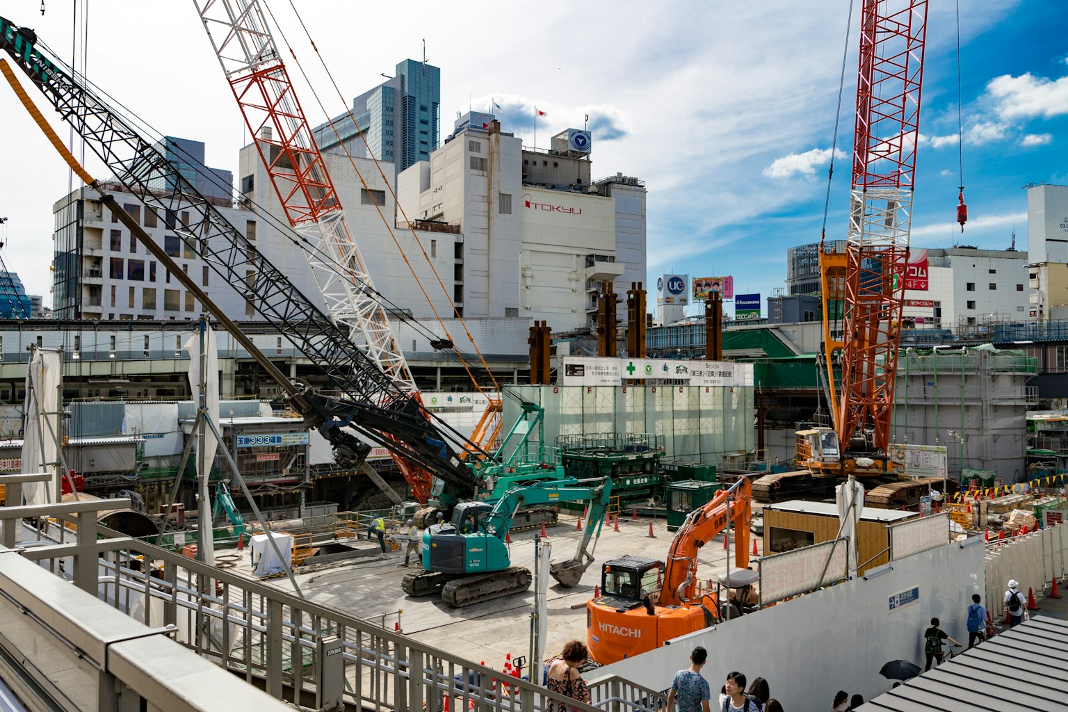 ไซต์ก่อสร้างในพื้นที่เมืองที่มีเครนและเครื่องจักรทำงาน