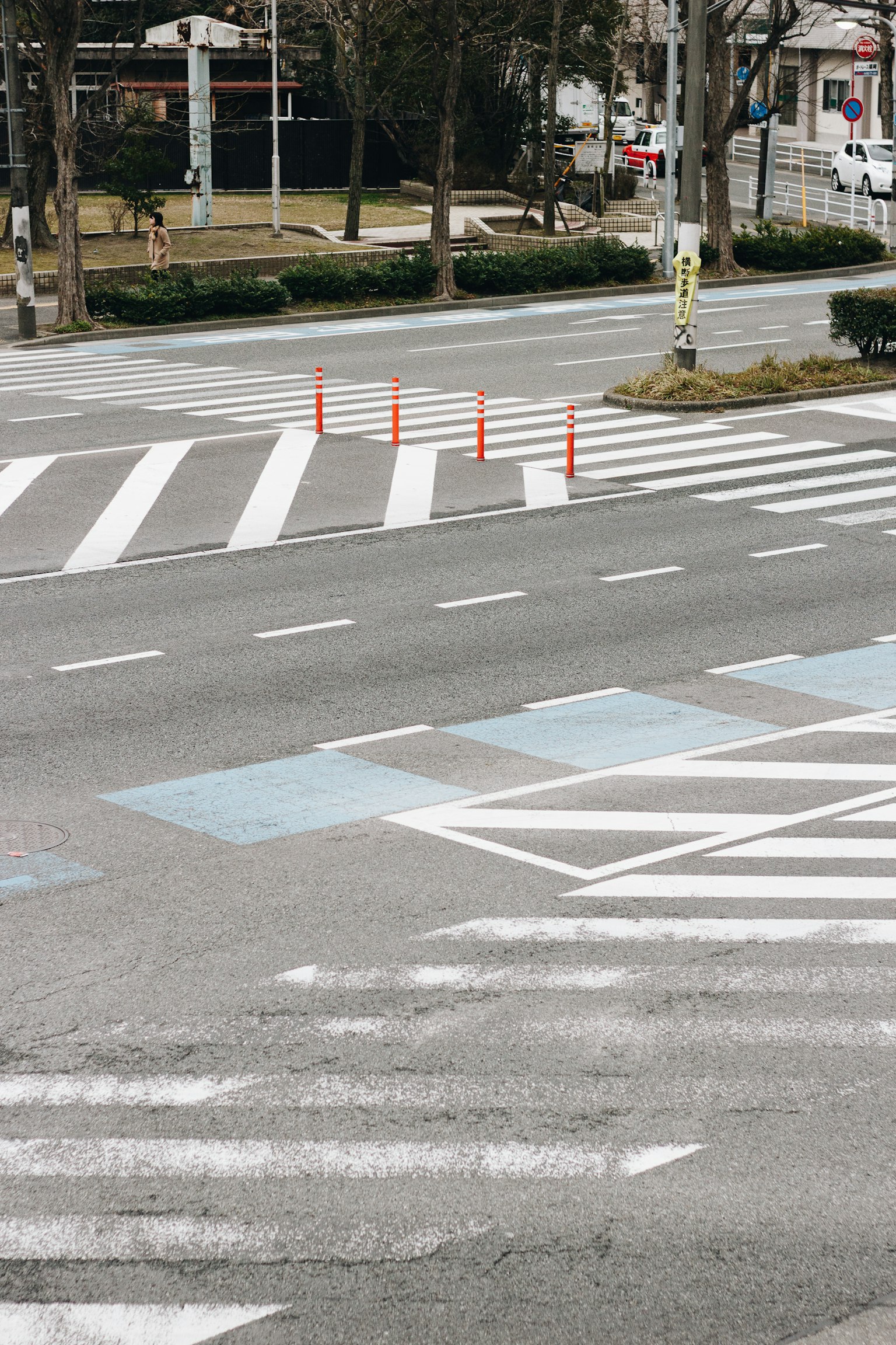 Intersection avec des passages piétons blancs et bleus et des cônes rouges